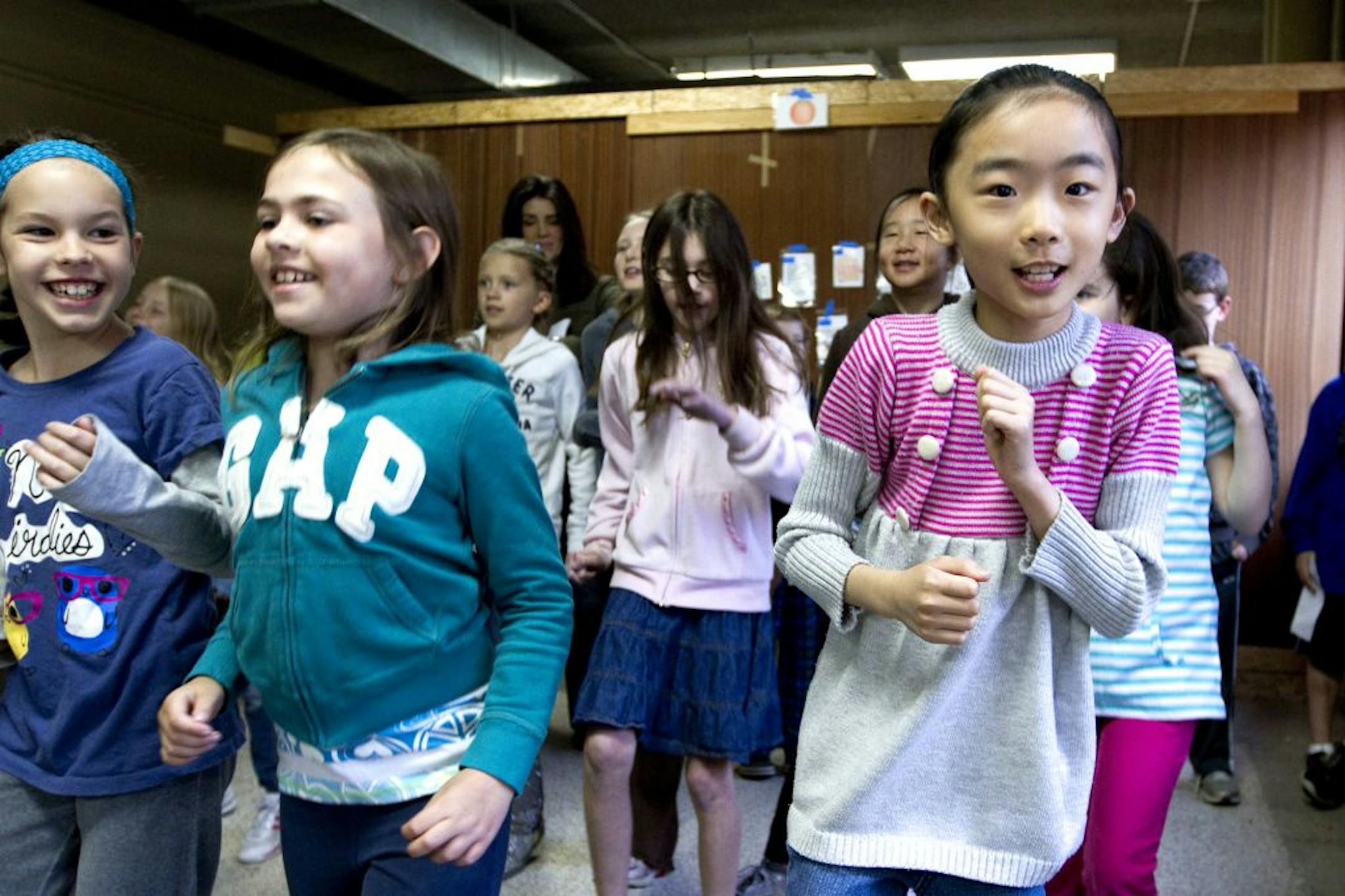 From left to right Carinn Tryon, Mara Prochaska and Bryanna Shao (cq'ed all with instructor) danced and sung "Waka Waka (This Time for Africa)" sung by Shakira in Ana Rayas's 4th year Spanish class on Friday April 13 at the St. Barnabas Church in Plymouth, Minn. The students are practicing the song for the 10th anniversary celebration Que Tal, the before-school Spanish program.