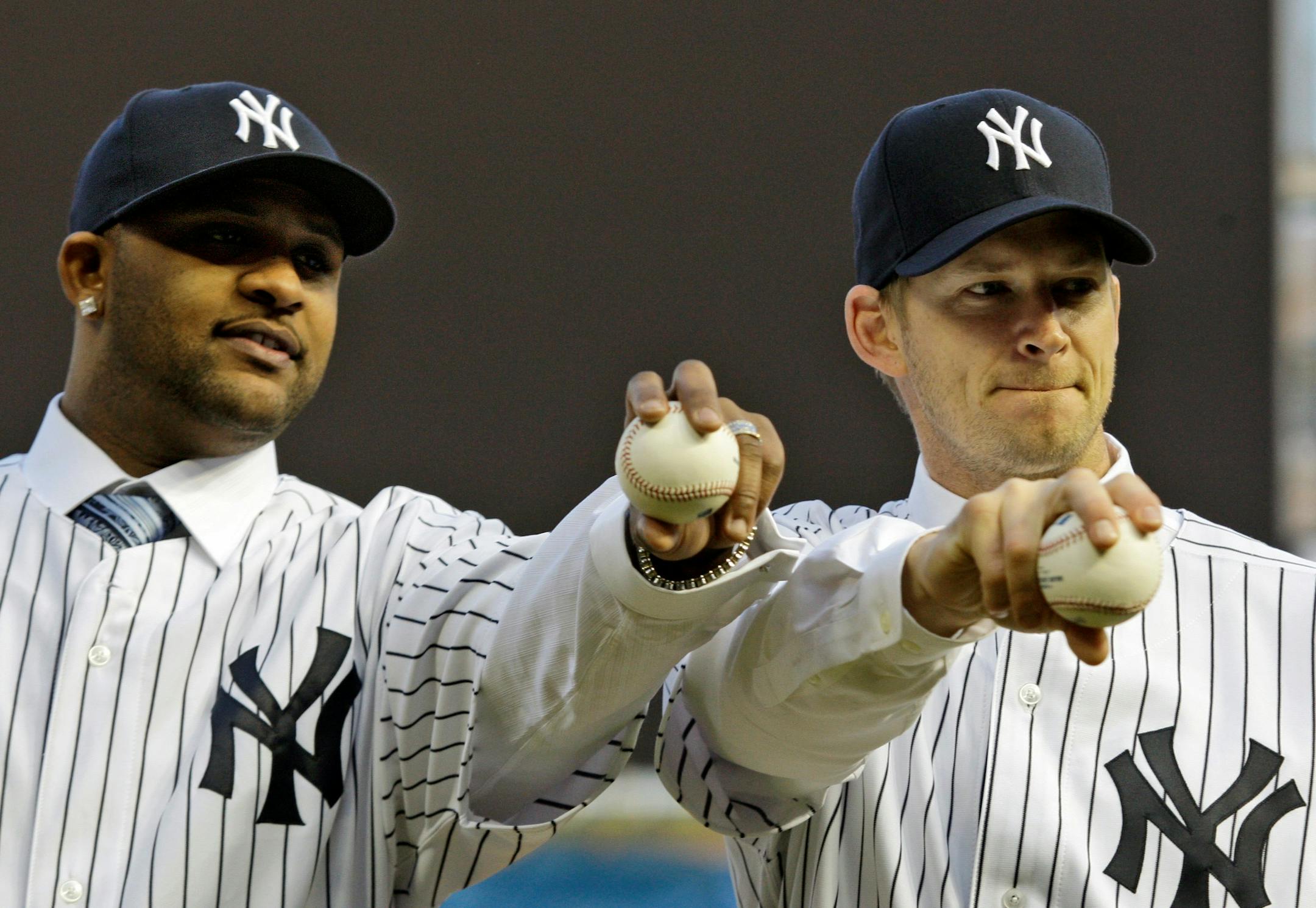 CC Sabathia, left, and A.J. Burnett, free-agent pitchers who recently finalized contracts with the New York Yankees, hold baseballs on the mound during a photo opportunity at the new Yankee Stadium in New York, Thursday, Dec. 18, 2008.