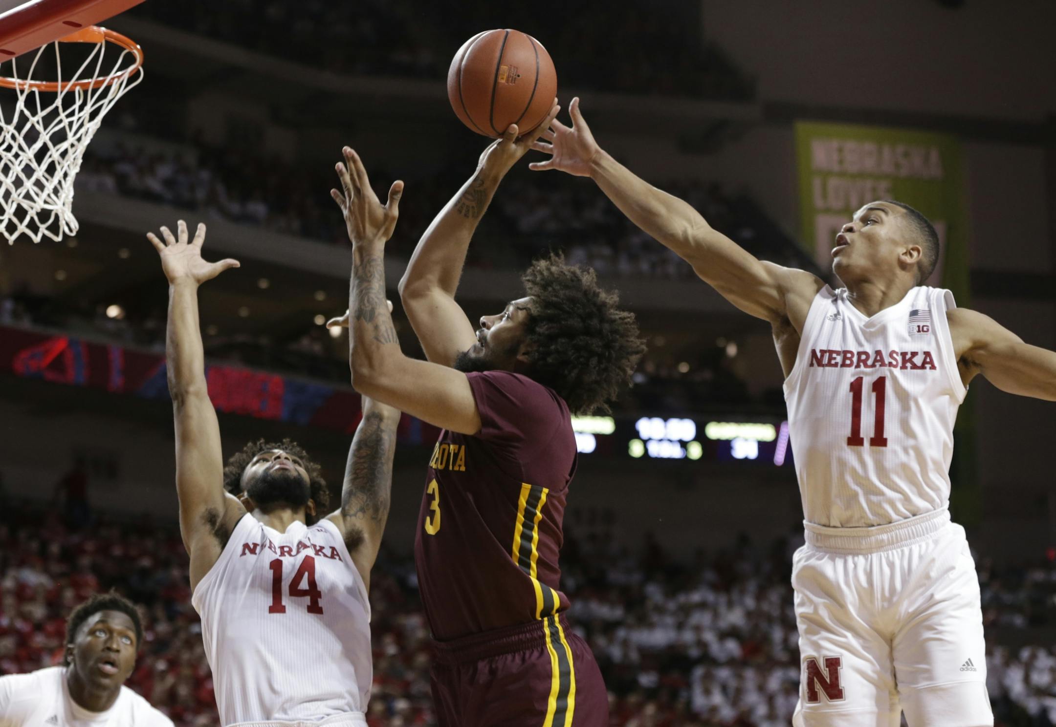 Minnesota's Jordan Murphy (3) shoots between Nebraska's Isaac Copeland (14) and Evan Taylor (11) during the second half of an NCAA college basketball game in Lincoln, Neb., Tuesday, Dec. 5, 2017. Nebraska won 78-68.