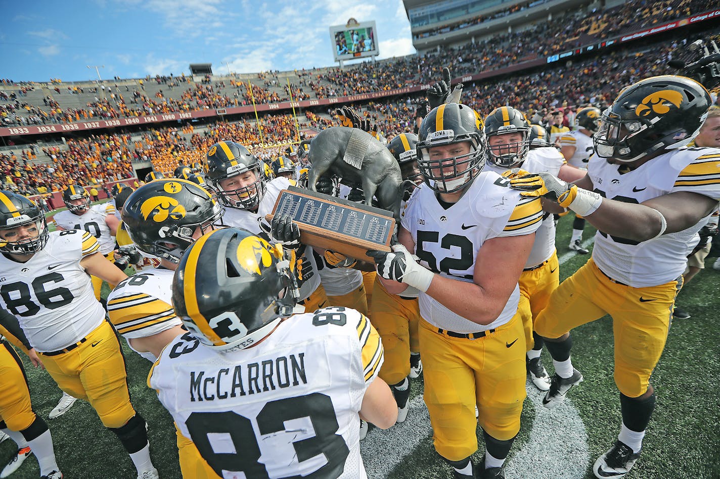 The Iowa Hawkeyes players celebrated a 14-7 win over Minnesota as they paraded on the field with the Floyd of Rosedale trophy at TCF Bank Stadium