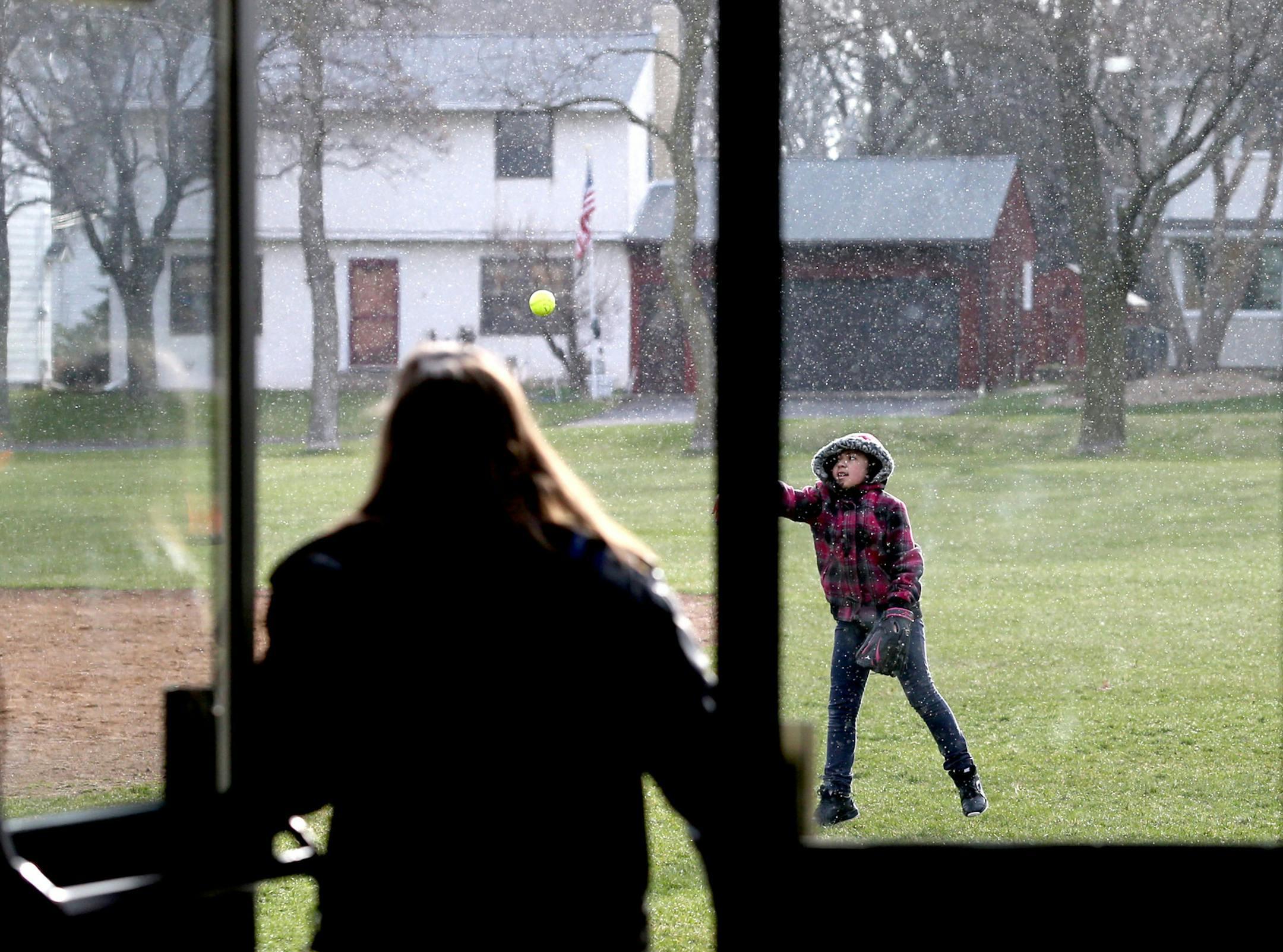 Fifth grader Iliana Vasquez had to wear her winter coat while out on recess but a little snow wasn't going to stop her from playing softball with a friend at Community of Saints Regional Catholic School Thursday, April 7, 2016, in West St. Paul, MN.](DAVID JOLES/STARTRIBUNE)djoles@startribune.com ORG XMIT: MIN1604071244181829