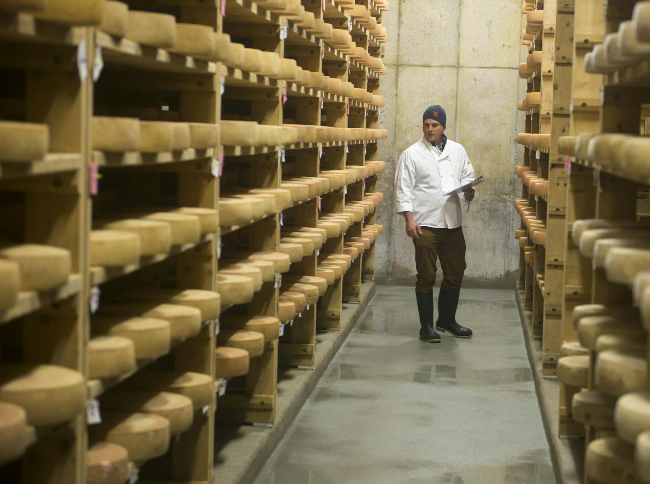 Mateo Kehler among the rows of cheeses aging in the cellar at Jasper Hill Farm in Greensboro, Vt., Nov. 18, 2016. The Kehler brothers' award-winning cheese dairy has a modern two-room laboratory, and Jasper Hill has become a hub for other cheese makers seeking help and insight. (Caleb Kenna/The New York Times)