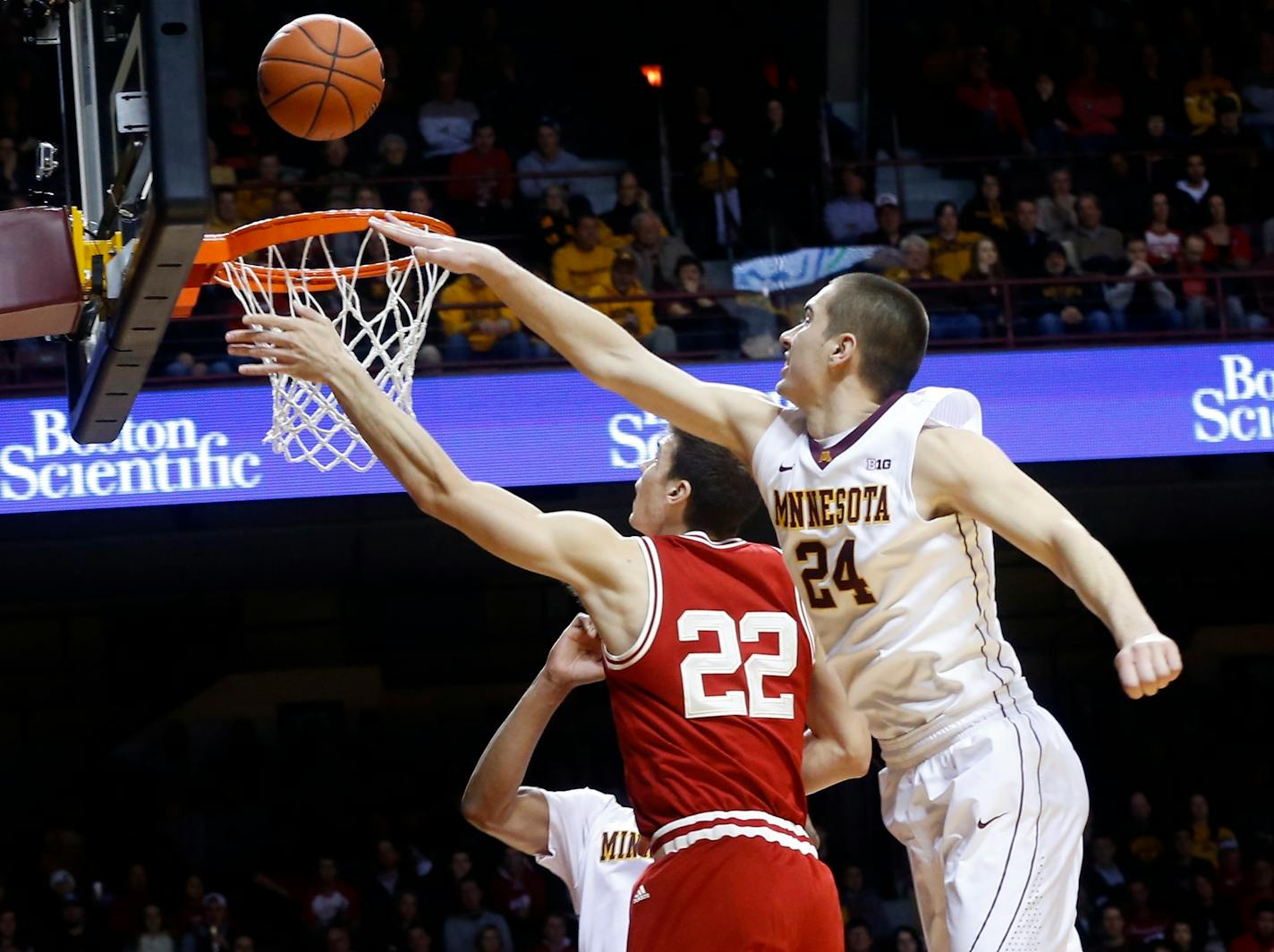 Wisconsin's Ethan Happ, left, lays up a shot as Minnesota's Joey King defends in the first half of an NCAA college basketball game Wednesday, March 2, 2016, in Minneapolis. (AP Photo/Jim Mone)