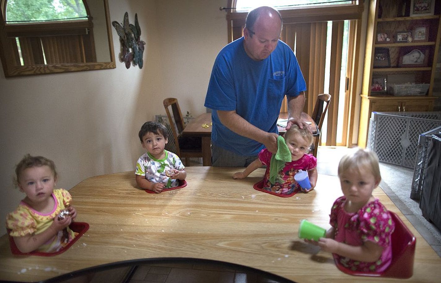 Travis Broskoff cleaned Hattie's face at the breakfast table, while fellow quadruplets Raegan, left, Shay and Lia awaited their turns.