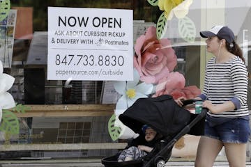 Now Open sign is displayed at a stationary store in Evanston, Ill., Friday, May 29, 2020. Every region of Illinois met the criteria to move into Phase