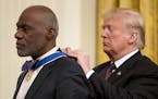 President Donald Trump awards former professional football player and Minnesota Supreme Court Associate Justice Alan Page the Medal of Freedom during 
