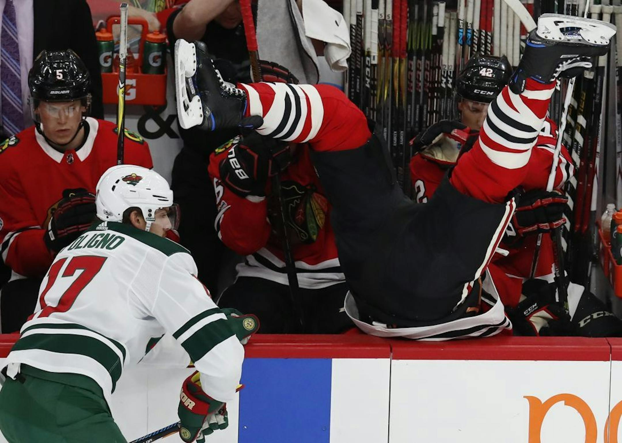 Chicago Blackhawks' Brent Seabrook, right, goes over the boards after missing a check on Minnesota Wild's Marcus Foligno during the first period of an NHL hockey game Thursday, Oct. 12, 2017, in Chicago.