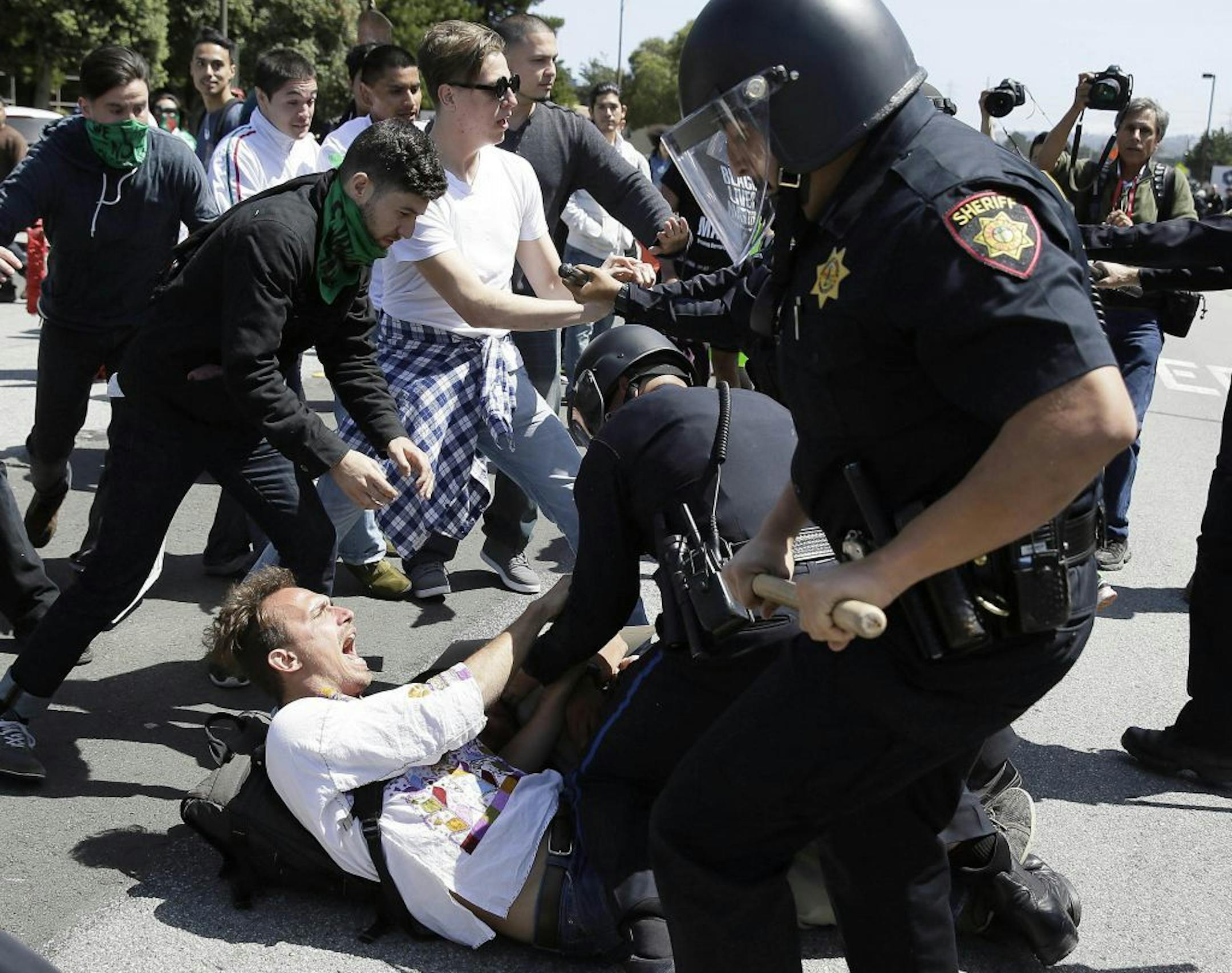 Police officers took a man into custody who was protesting Donald Trump outside of the Hyatt Regency hotel during the California Republican Party 2016 Convention in Burlingame, Calif., on Friday.
