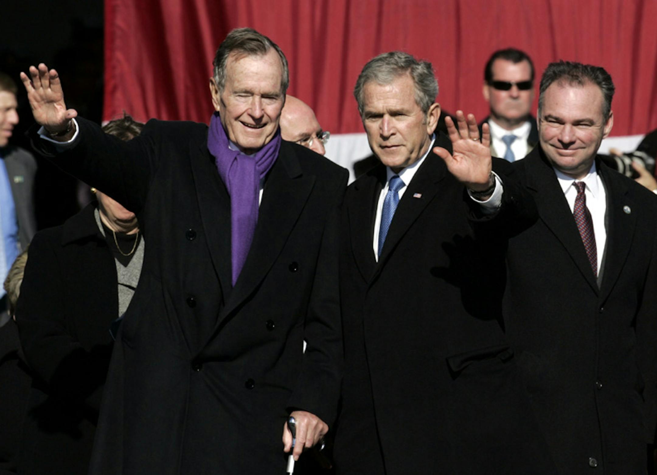 President George W. Bush and his father former President George H.W. Bush wave to the crowd after commissioning ceremonies for the USS George H.W. Bush at Naval Station Norfolk in Norfolk, Va., Saturday, Jan. 10, 2009. Virginia Gov. Timothy M. Kaine is at right. (AP Photo/Steve Helber)