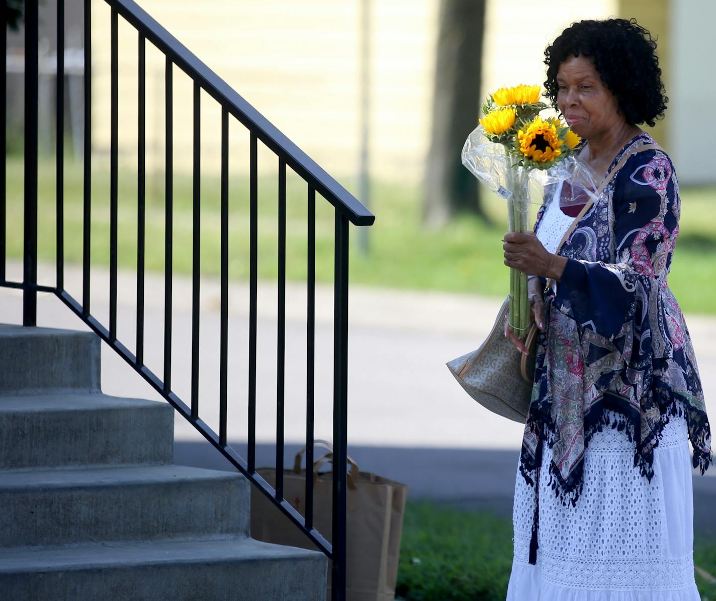 Mary Peeples, who lives near St. Albans Church of God, the scene of a fatal shooting late Wednesday, leaves flowers outside the church. Police say a St. Paul man leaving Bible study with his father and young daughter was fatally shot outside his church Wednesday night, becoming the city's 20th homicide victim of the year. "Just pray for them," was Peeples advice on what to do.