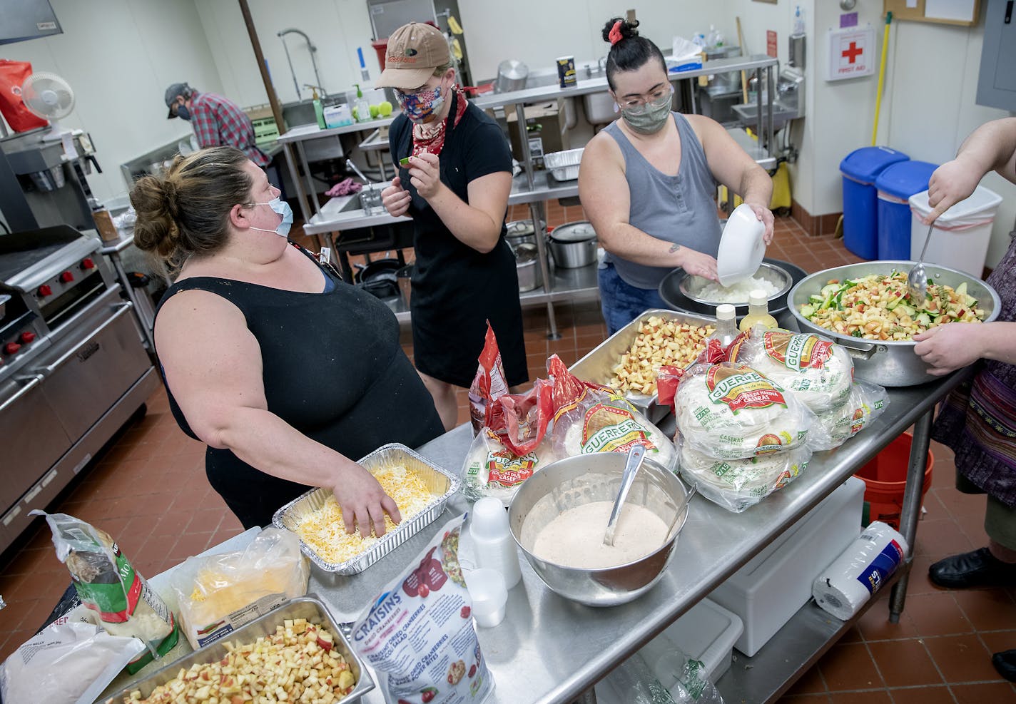 Jennifer Lancour, left, worked with volunteers making meals at First Congregational Church. Homegrown mutual aid groups are popping up all over.