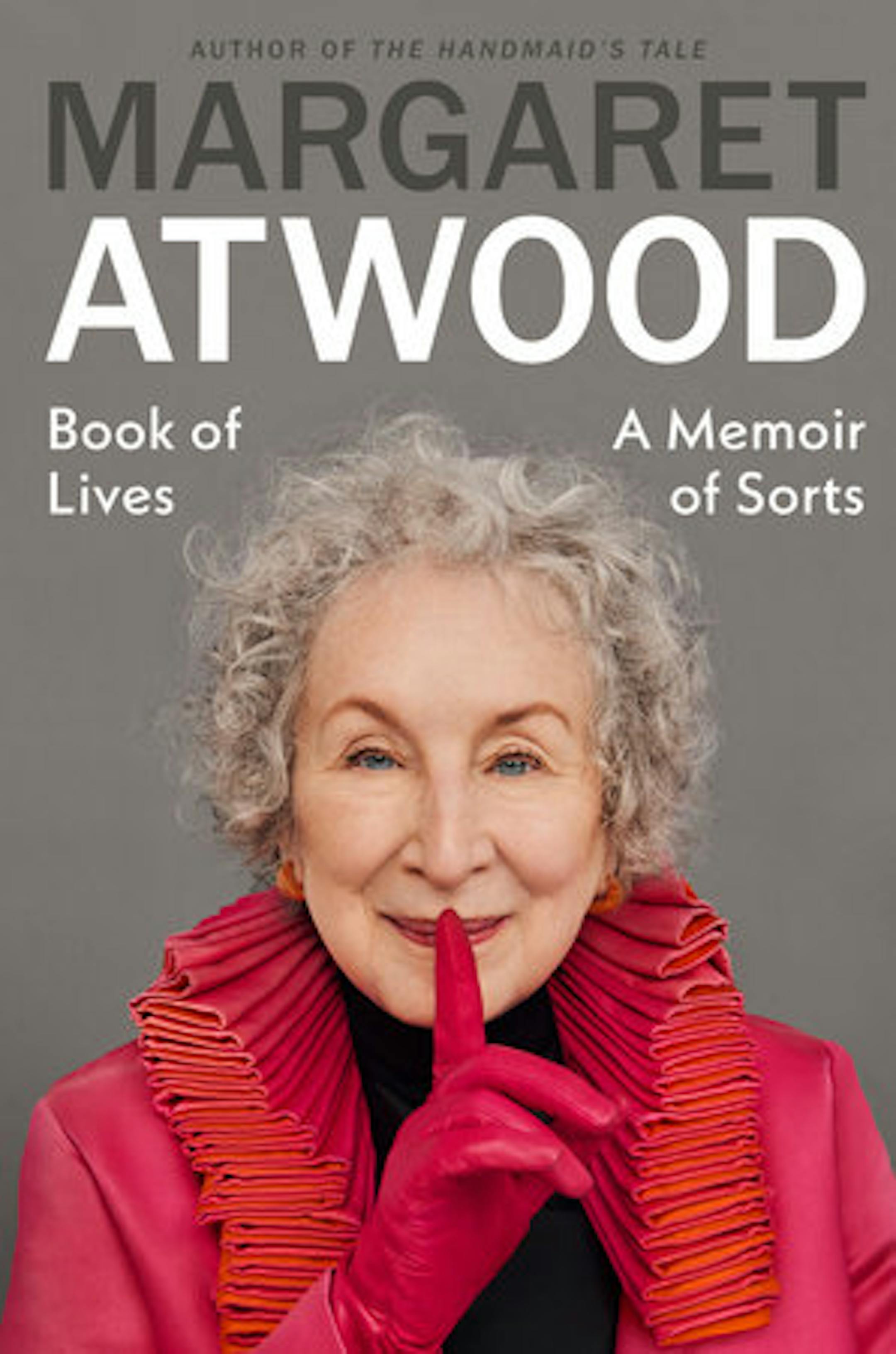cover of Book of Lives is a photo of author Margaret Atwood, clad in pink and red, shushing us