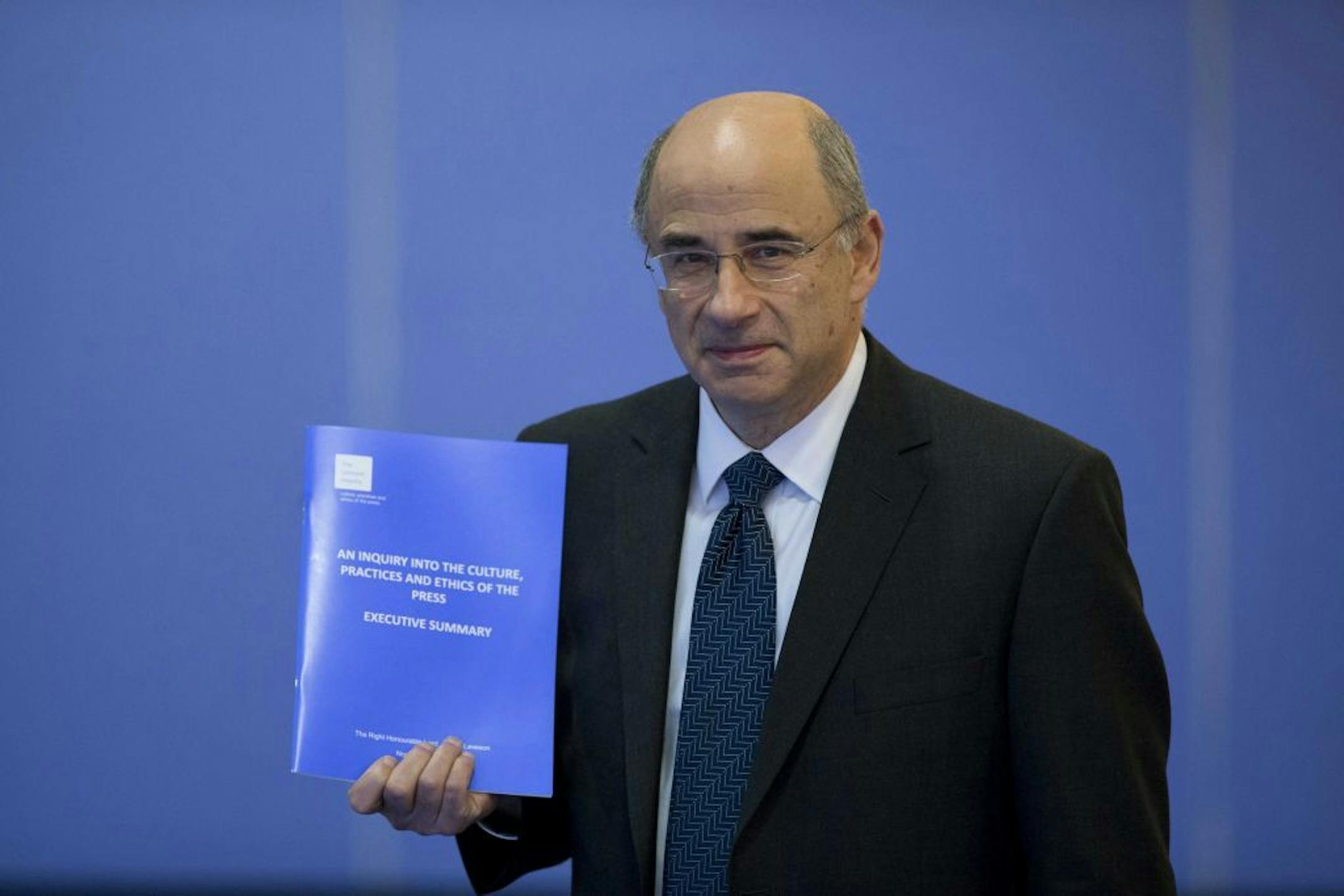 Britain's Lord Justice Brian Leveson holds a summary of his report whilst posing for photographers before its release at the Queen Elizabeth II Conference Centre in London, Thursday, Nov. 29, 2012. After a yearlong inquiry full of sensational testimony, Britain's Lord Justice Brian Leveson is releasing his report Thursday into the culture and practices of the British press and his recommendations for future regulation to prevent phone hacking, data theft, bribery and other abuses.