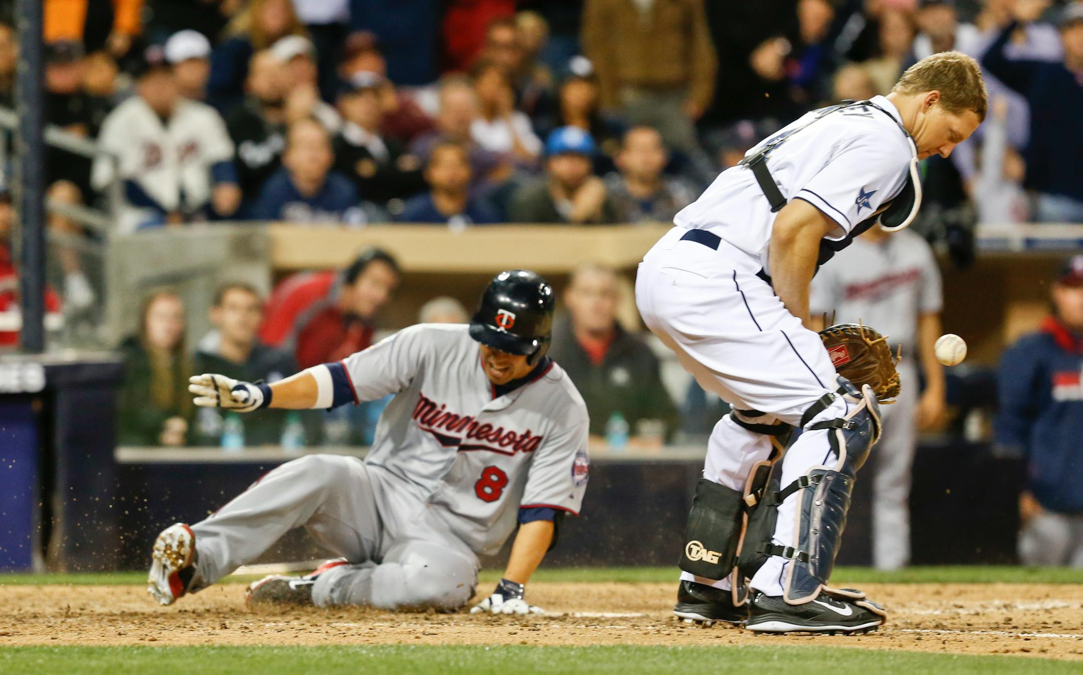 San Diego Padres catcher Nick Hundley knocks down the late throw as Minnesota Twins' Kurt Suzuki slides in with an inside-the-park home run during the eighth inning of a baseball game Tuesday, May 20, 2014, in San Diego. (AP Photo/Lenny Ignelzi)