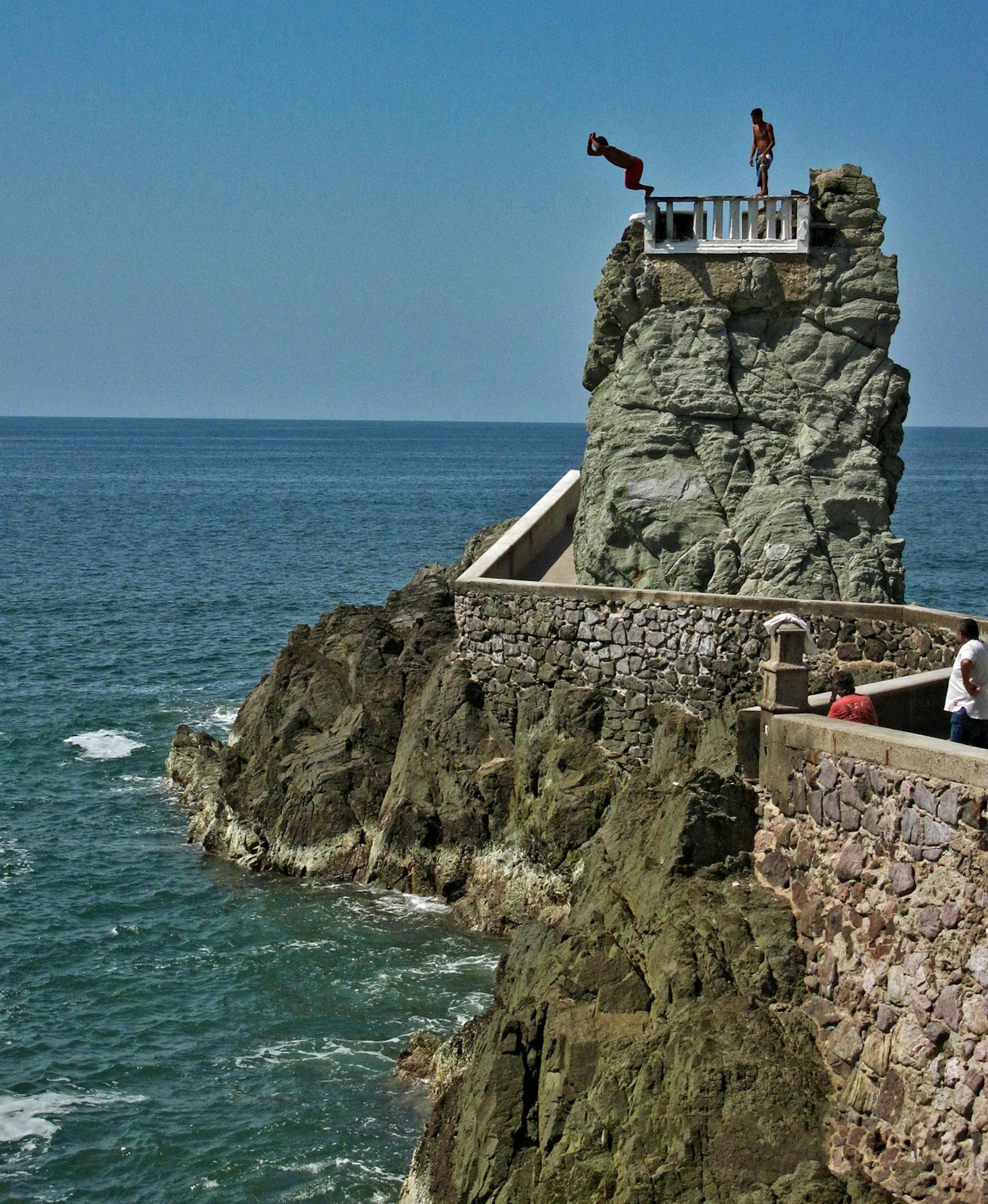 Stunt divers on Mirador Rock, on the Malecon, brave surging waves for a tip from visitors in Mazatlan, Mexico.
