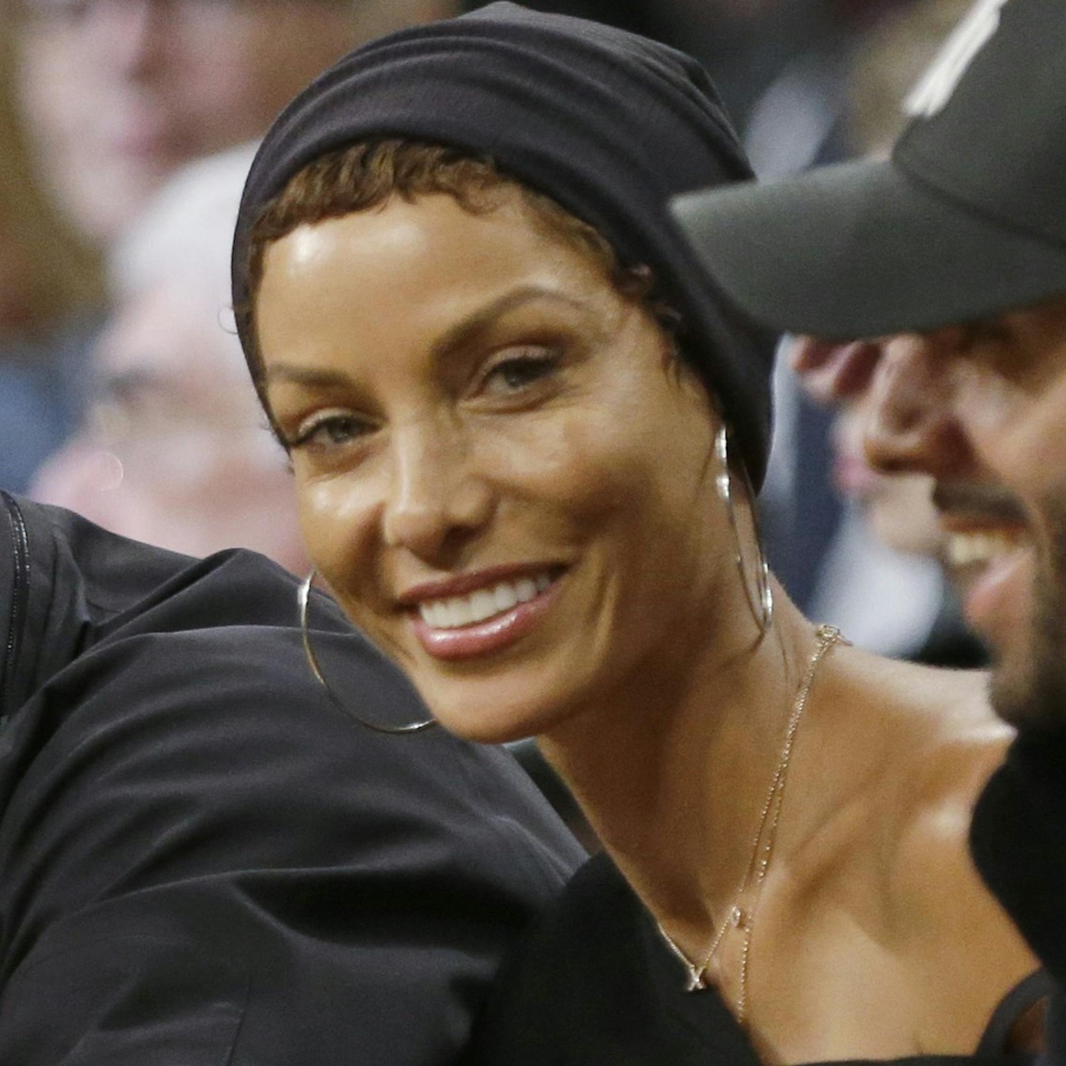 Michael Strahan, left, and Nicole Murphy smile during the first half of an NBA basketball game between the New York Knicks and the Brooklyn Nets on Tuesday, April 15, 2014, in New York. (AP Photo/Frank Franklin II)