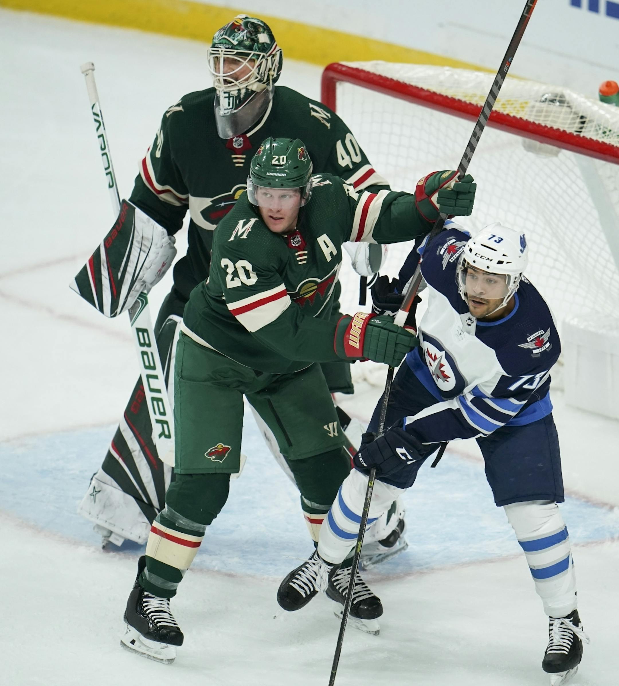 Minnesota Wild defenseman Ryan Suter (20) dirstracted Jets left wing C.J. Suess (73) while they waited for an incoming shot in the crease in front of Wild goaltender Devan Dubnyk in the third period.