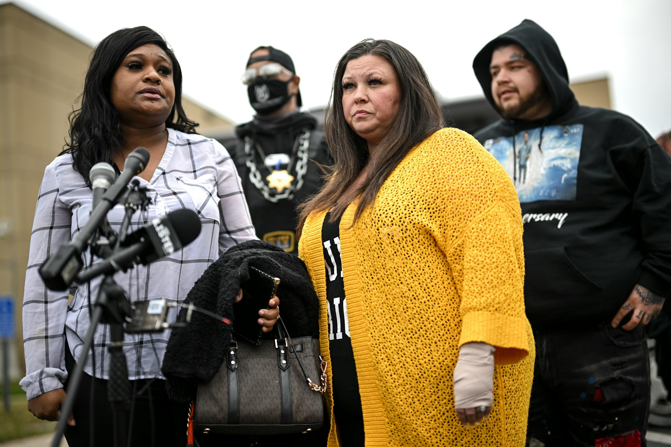 Katie Wright, center, stands beside activist Toshira Garraway and her son, Damik Bryant, during a news conference.