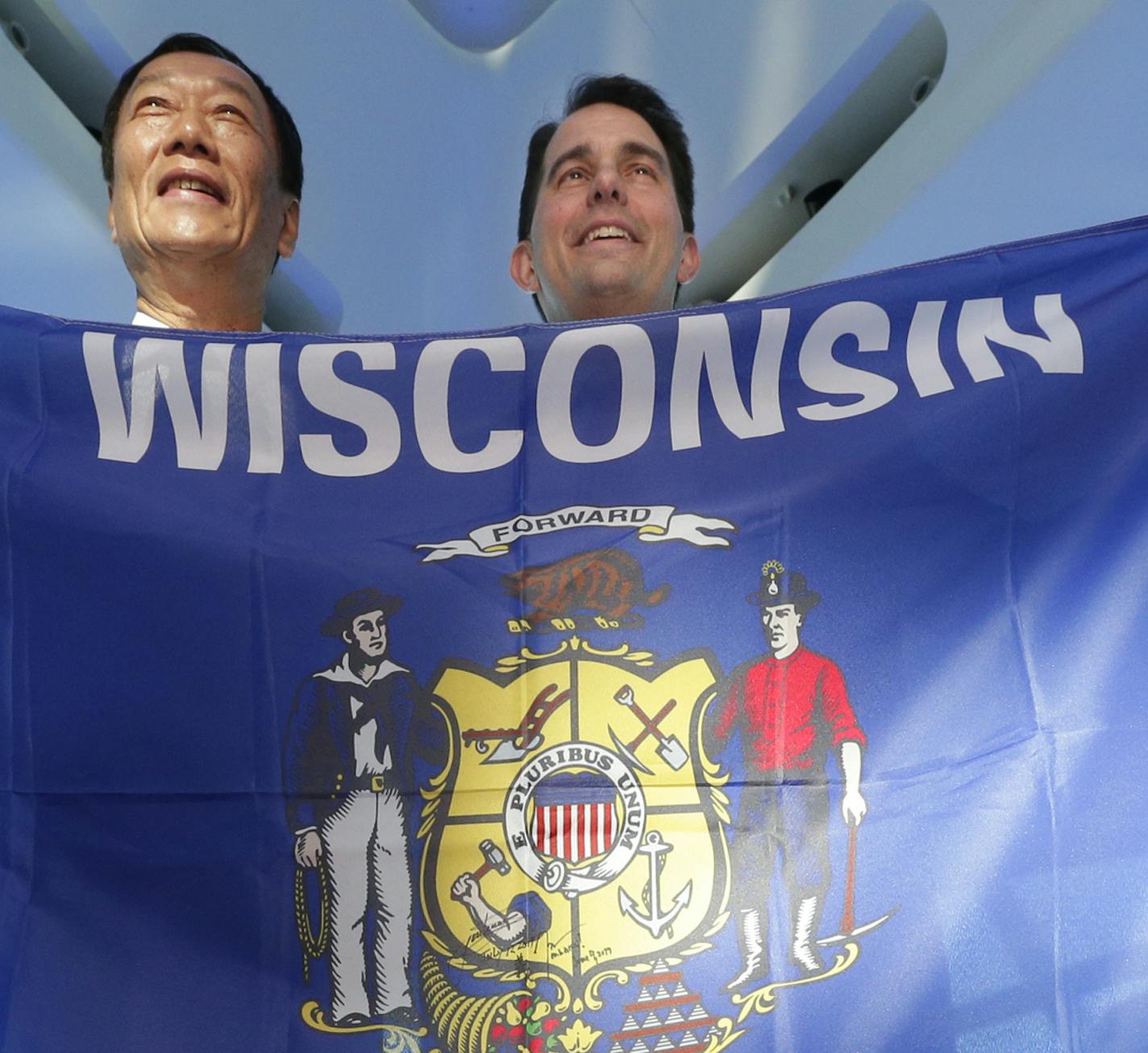 Foxconn Chairman Terry Gou, left, and Gov. Scott Walker hold the Wisconsin flag to celebrate their $10 billion investment to build a display panel plant in Wisconsin, at the Milwaukee Art Museum in Milwaukee, Wis., Thursday, July 27, 2017. (Mike De Sisti/Milwaukee Journal-Sentinel via AP)