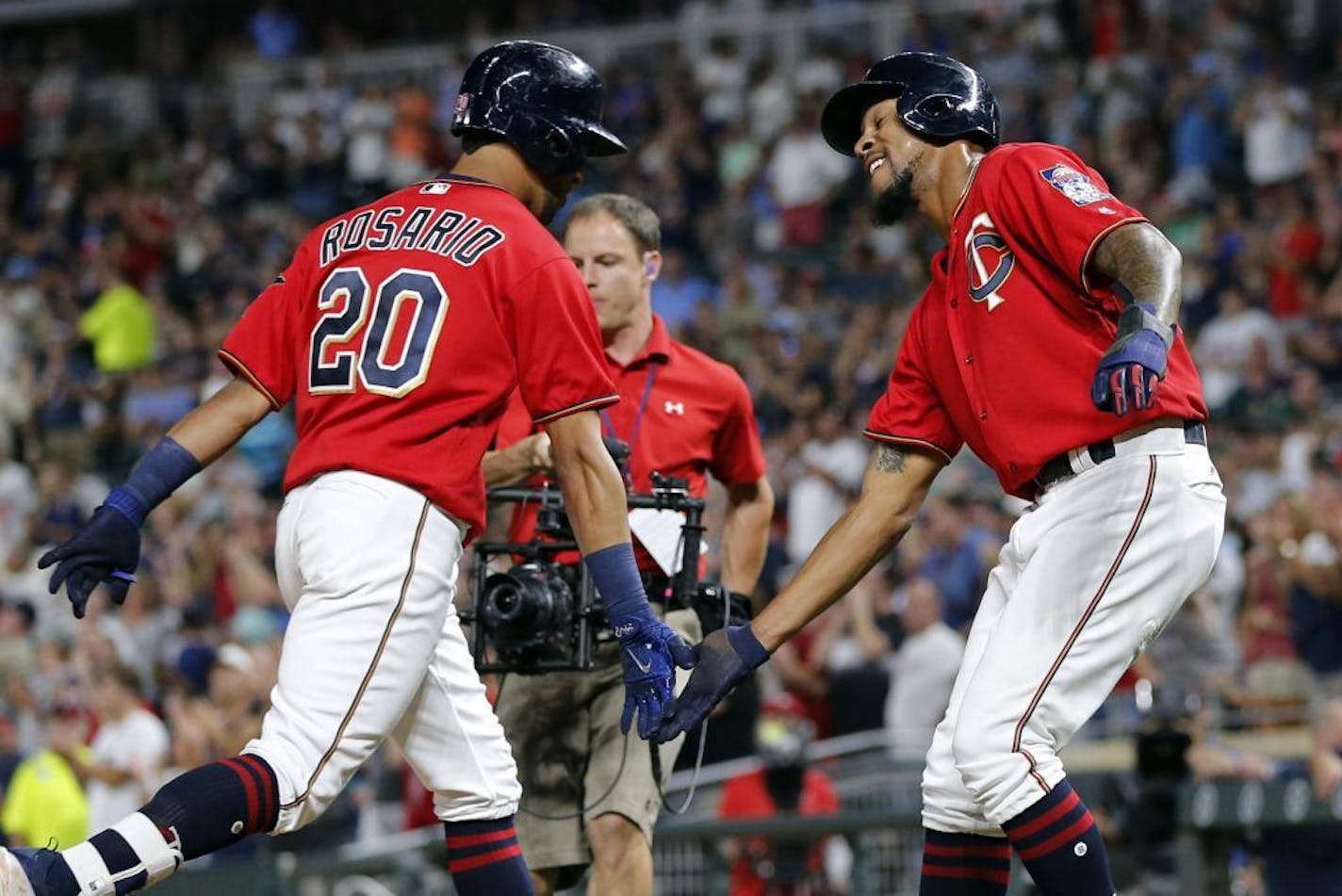 Minnesota Twins' Eddie Rosario, left, is congratulated by Byron Buxton after Rosario's two run home run off San Diego Padres relief pitcher Jose Valdez in the fourth inning of a baseball game Tuesday, Sept. 12, 2017, in Minneapolis.