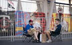 Luke Widbin and Nathan Heerts ate some take out as they parked their chairs at gate 34 to listen to the Twins home opener on their phones as it happen
