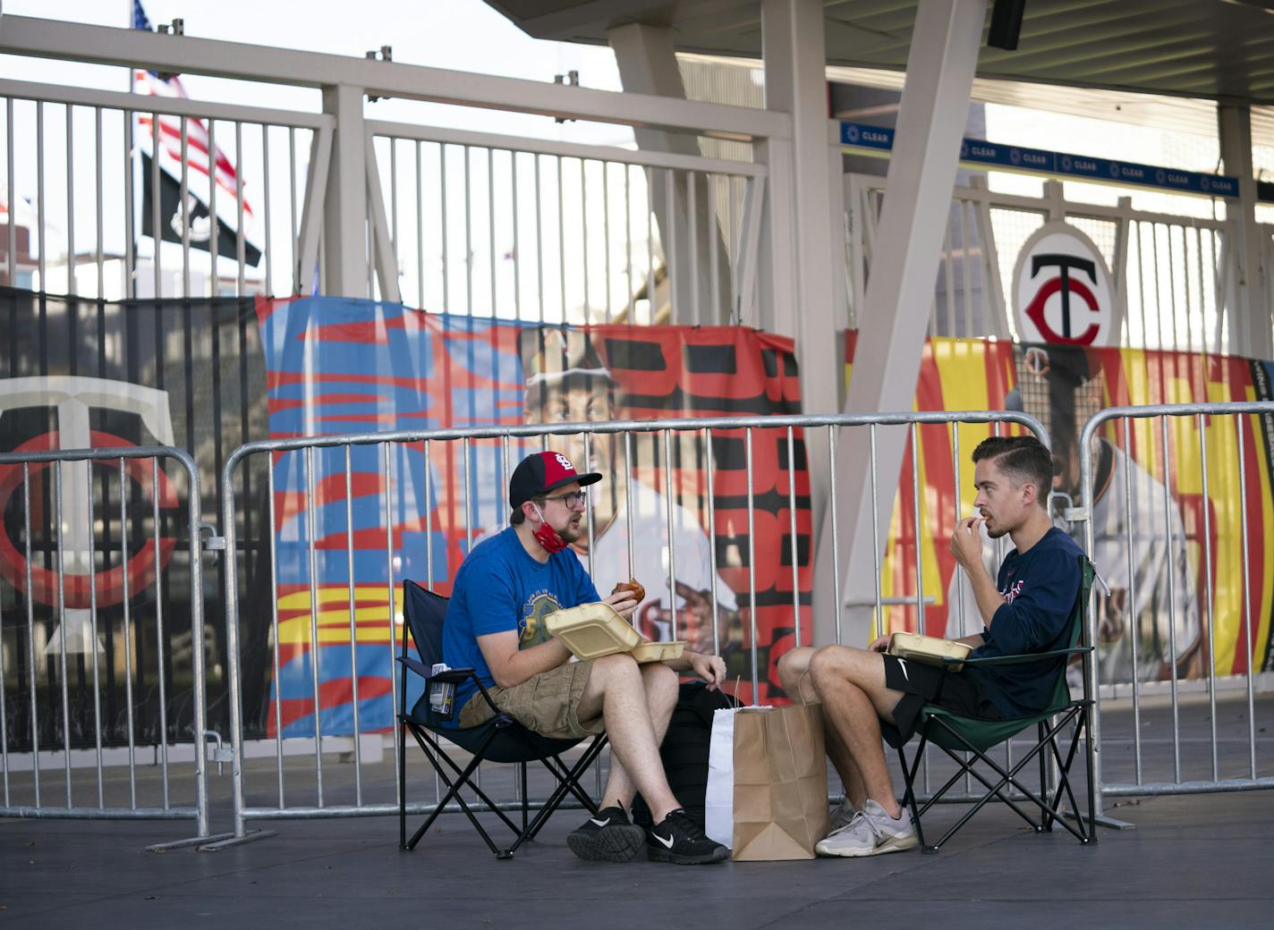 Luke Widbin and Nathan Heerts ate some take out as they parked their chairs at gate 34 to listen to the Twins home opener on their phones as it happened in Target Field in Minneapolis, Minn., on Tuesday, July 28, 2020. ] RENEE JONES SCHNEIDER renee.jones@startribune.com