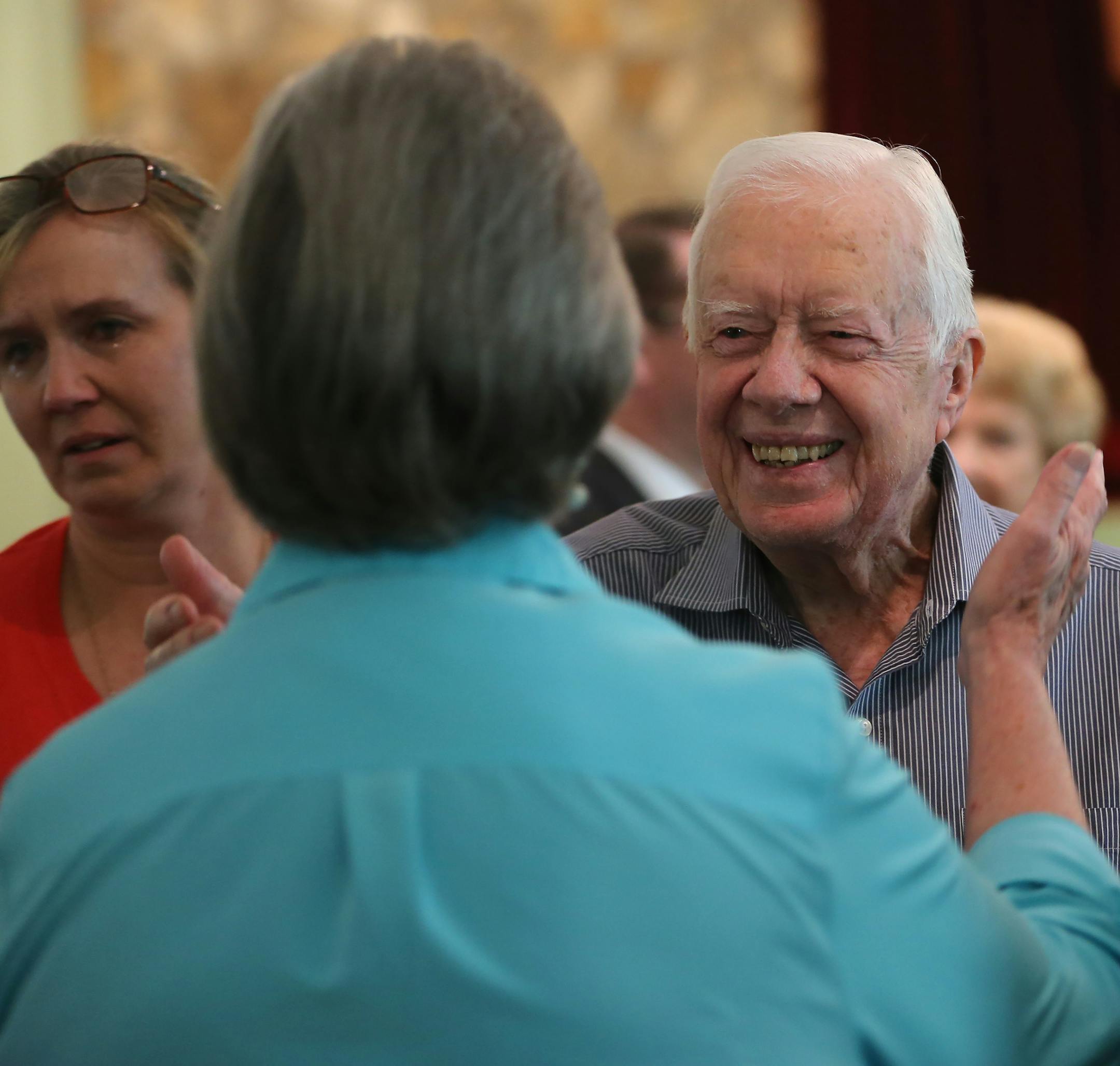 Former President Jimmy Carter reaches to embrace his brother Billy's widow Sybil while greeting family Sunday, Aug. 16, 2015, following service at Maranatha Baptist Church in Plains, Ga. Carter's nieces Mandy Flynn, left, and Jana Carter are also pictured. Sunday at church was emotional because it was the first time many members had seen Carter since his announcement that he has cancer. (Ben Gray/Atlanta Journal-Constitution via AP)