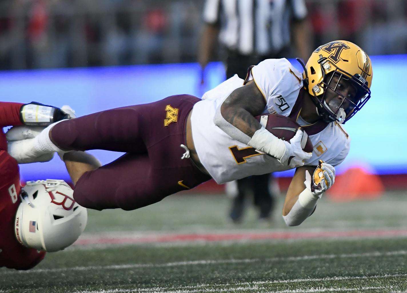 Gophers running back Rodney Smith (1) leapt for an extra yard as he was tackled by Rutgers linebacker Tyshon Fogg (8).