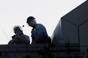 A Minneapolis police officer fired a rubber bullet from atop the Minneapolis Police Department Third Precinct station on E. Lake St. during unrest fol