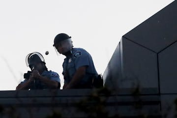 A Minneapolis police officer fired a rubber bullet from atop the Minneapolis Police Department’s Third Precinct station on E. Lake Street during a t