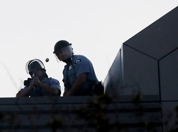 A Minneapolis police officer fired a rubber bullet from atop the Minneapolis Police Department Third Precinct station on E. Lake St. during unrest fol