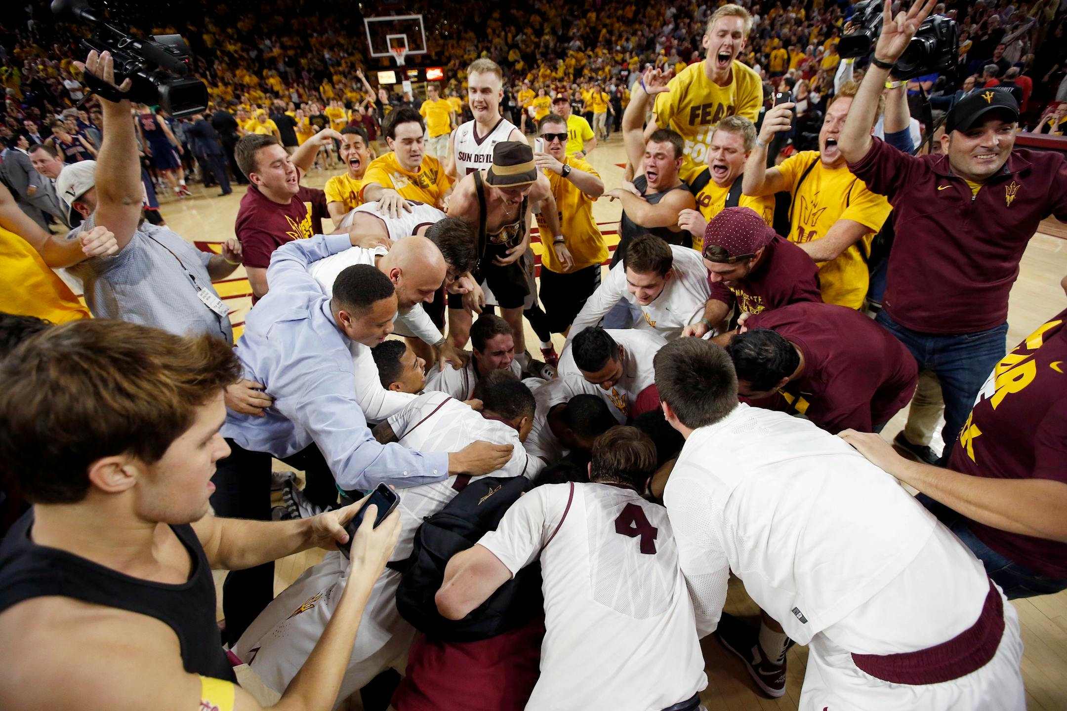 Arizona State players and fans celebrates after an NCAA college basketball game victory against Arizona, Friday, Feb. 14, 2014, in Tempe, Ariz. Arizona State defeated Arizona 69-66 in double overtime. (AP Photo/Ross D. Franklin)