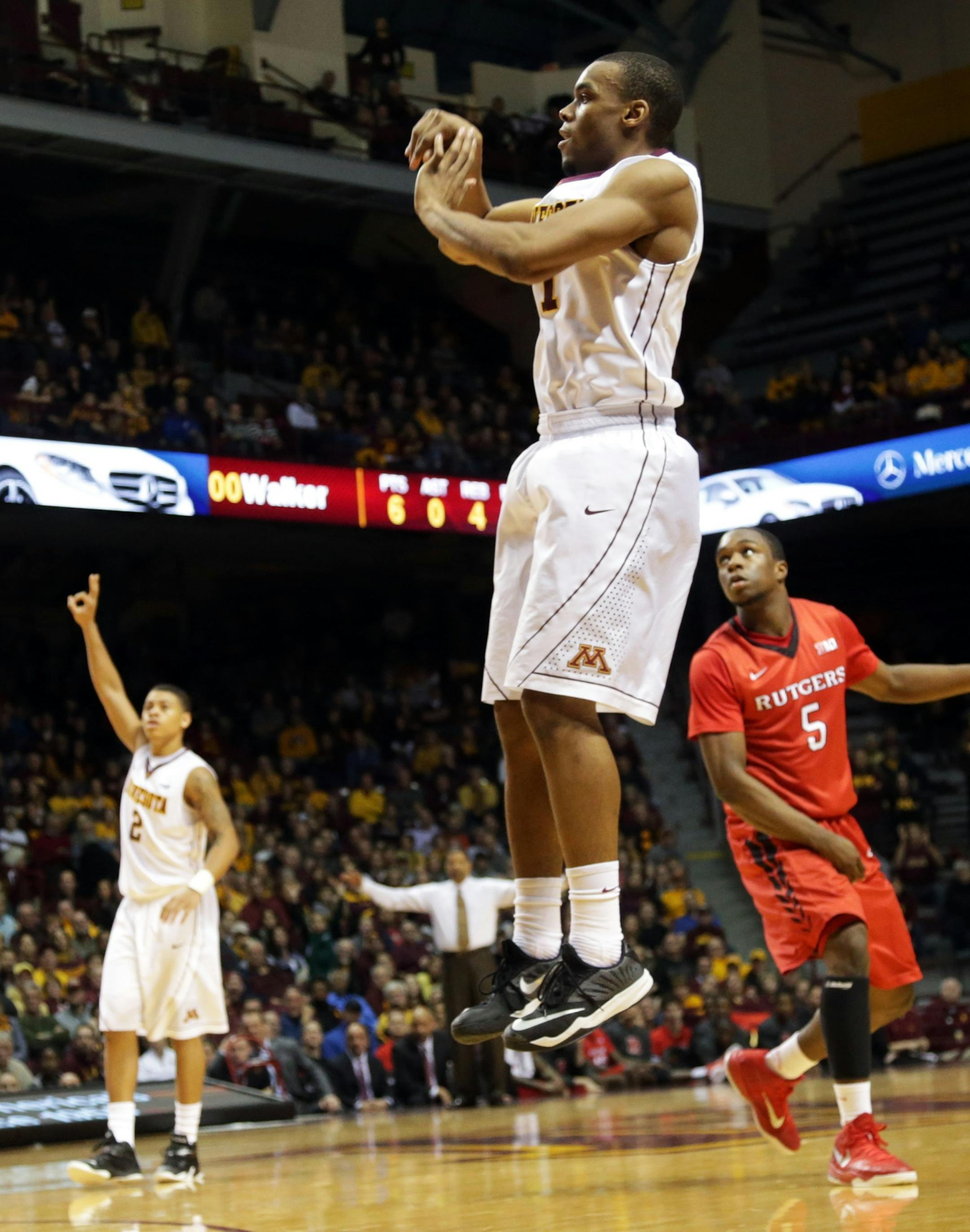 Minnesota&#x2019;s Andre Hollins watches one of his shots, along with Rutgers&#x2019;s Mike Williams, right, in the second half of an NCAA college basketball game, Saturday, Jan. 17, 2015, in Minneapolis. Hollins led Minnesota with 31 points in their 89-80 win. (AP Photo/Jim Mone)