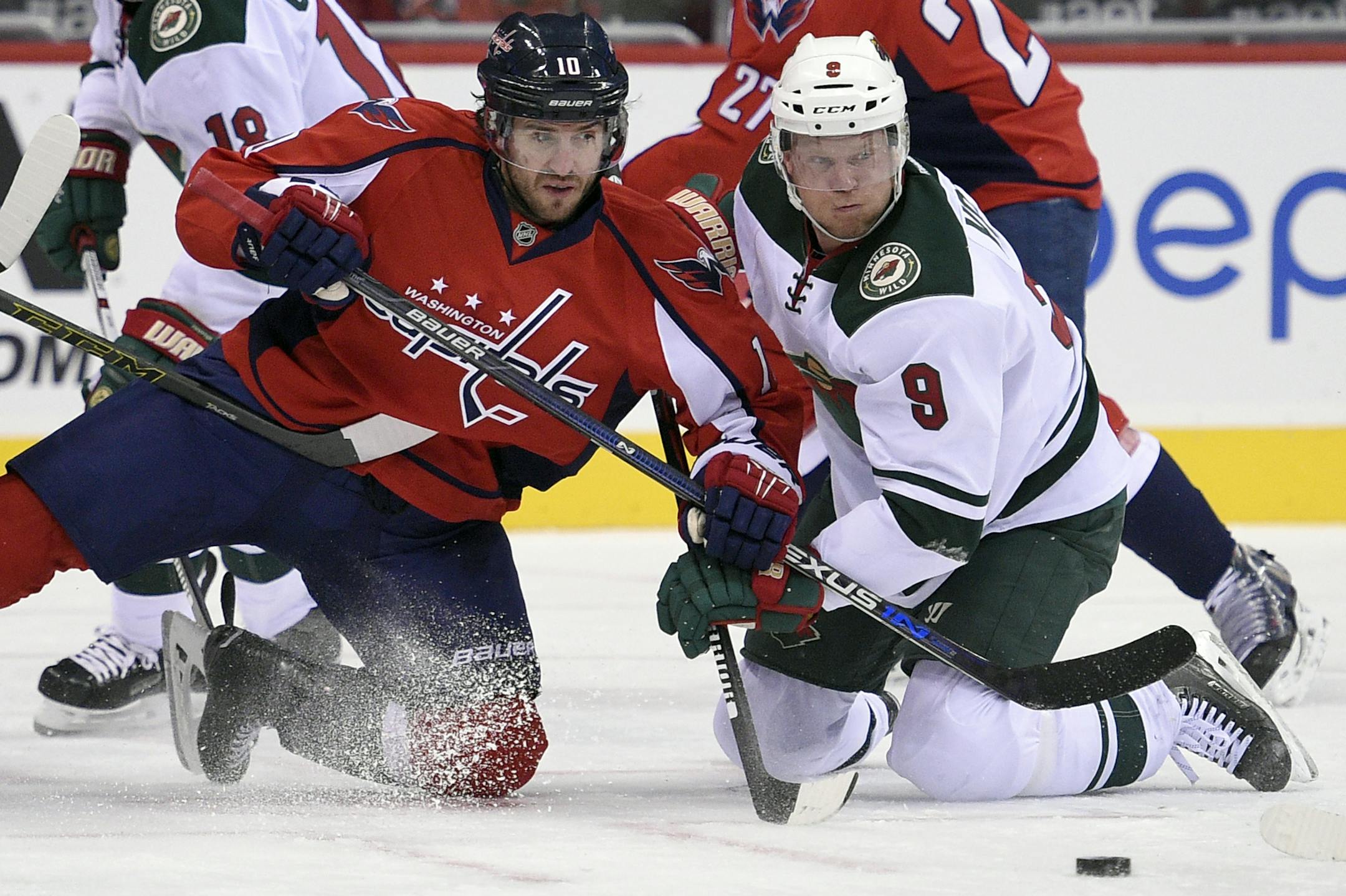 Washington Capitals center Mike Richards (10) battles for the puck against Minnesota Wild center Mikko Koivu (9), of Finland, during the first period of an NHL hockey game Friday, Feb. 26, 2016, in Washington. (AP Photo/Nick Wass)
