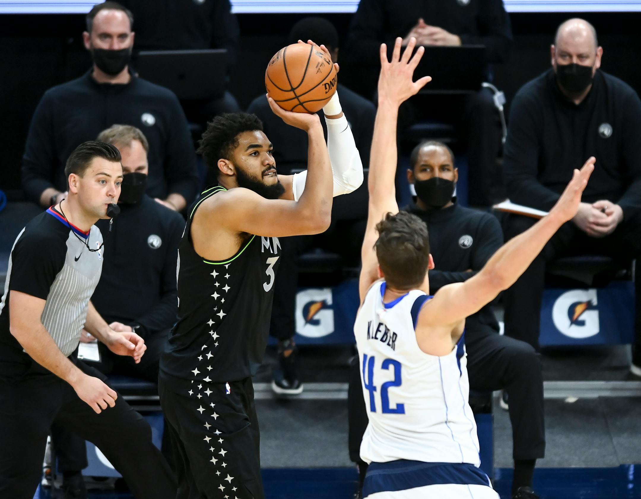 Minnesota Timberwolves center Karl-Anthony Towns (32) hit a 3-pointer as he was defended by Dallas Mavericks forward Maxi Kleber (42) in the first half.