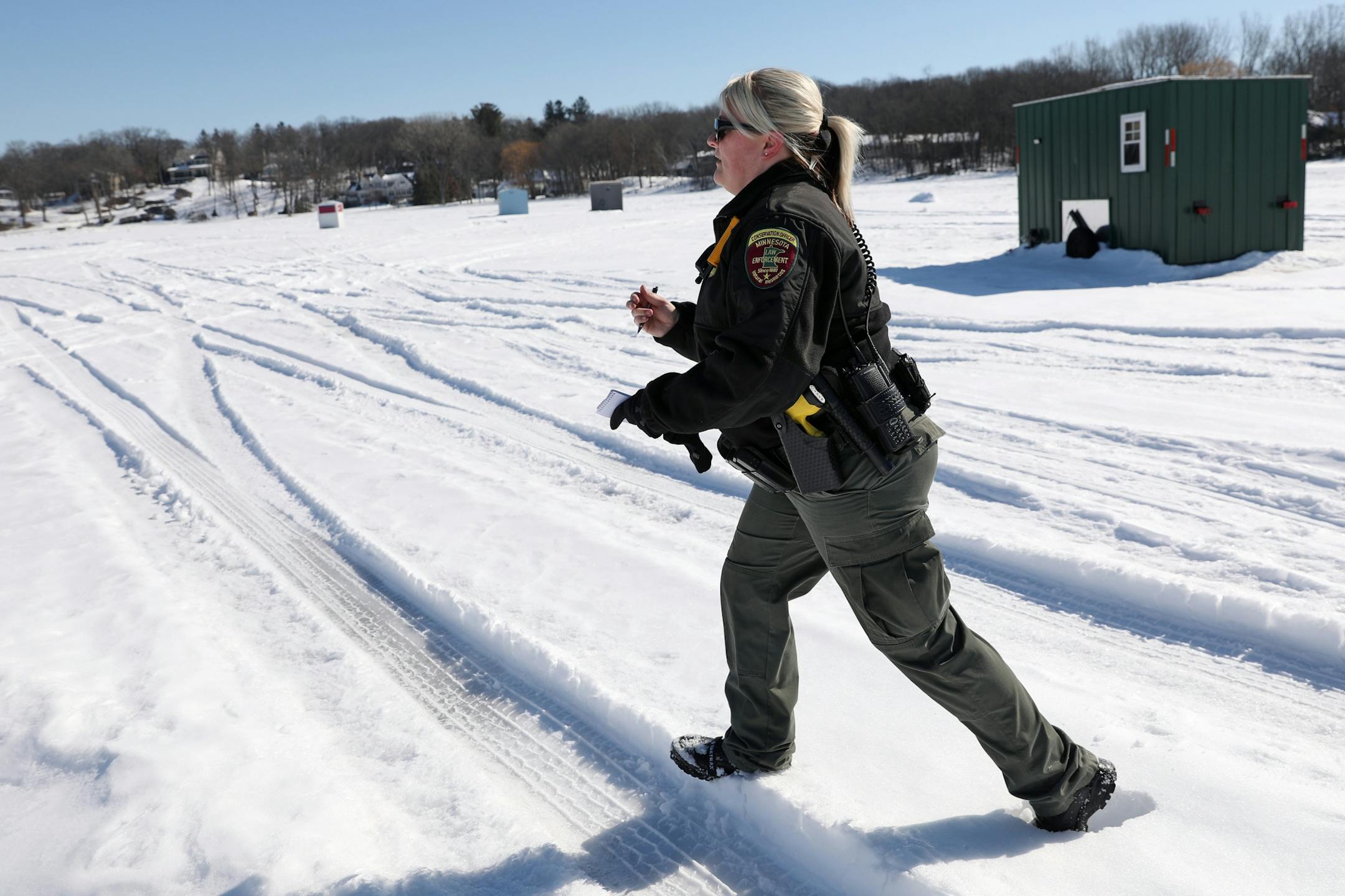 Minnesota Department of Natural Resources conservation officer Leah Weyandt walked to talk with anglers about the upcoming deadline to remove their ice fishing shelters Thursday at Lake Minnetonka.