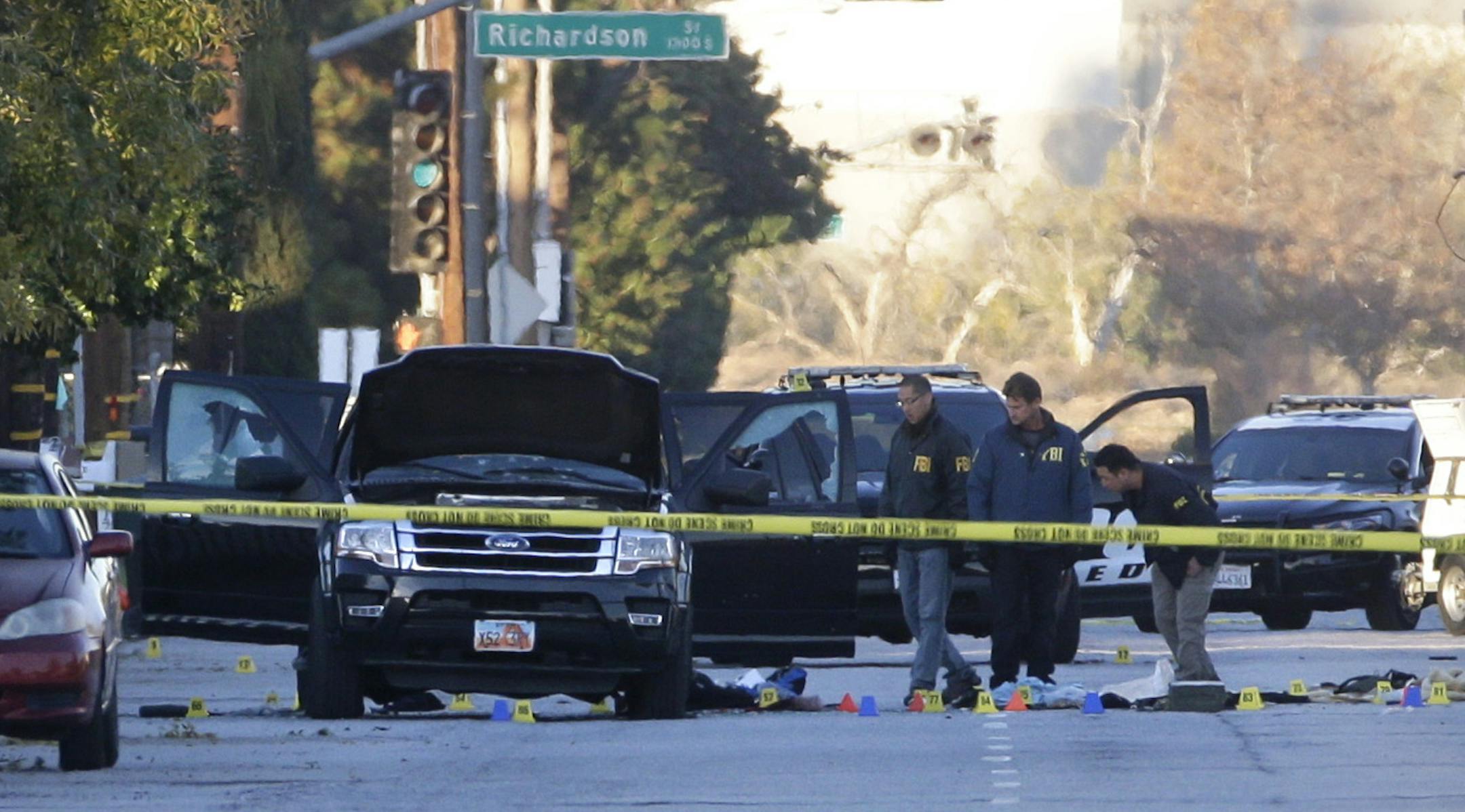 Authorities investigate the scene where a police shootout with suspects took place, Thursday, Dec. 3, 2015, in San Bernardino, Calif. A heavily armed man and woman opened fire Wednesday on a holiday banquet, killing multiple people and seriously wounding others in a precision assault, authorities said. Hours later, they died in a shootout with police. (AP Photo/Jae C. Hong) ORG XMIT: MIN2015120310325408