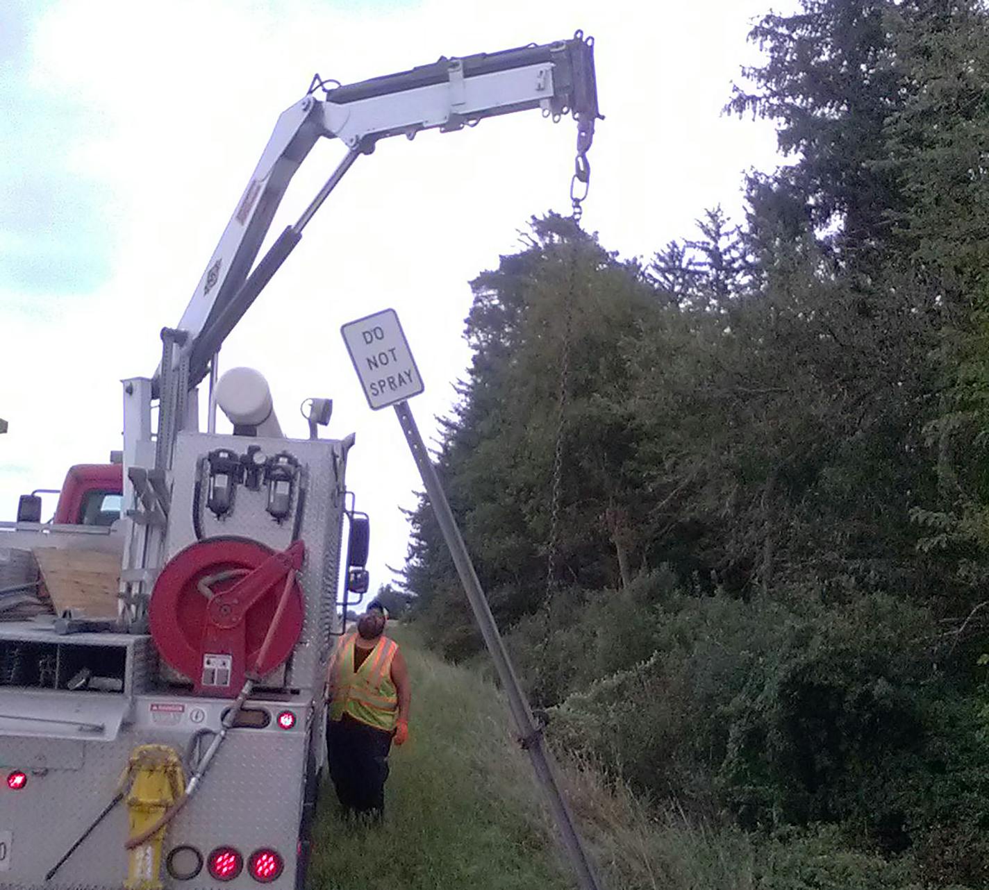 A MnDOT maintenance worker removes the Do Not Spray sign from the ditch abutting David Weissing's land.