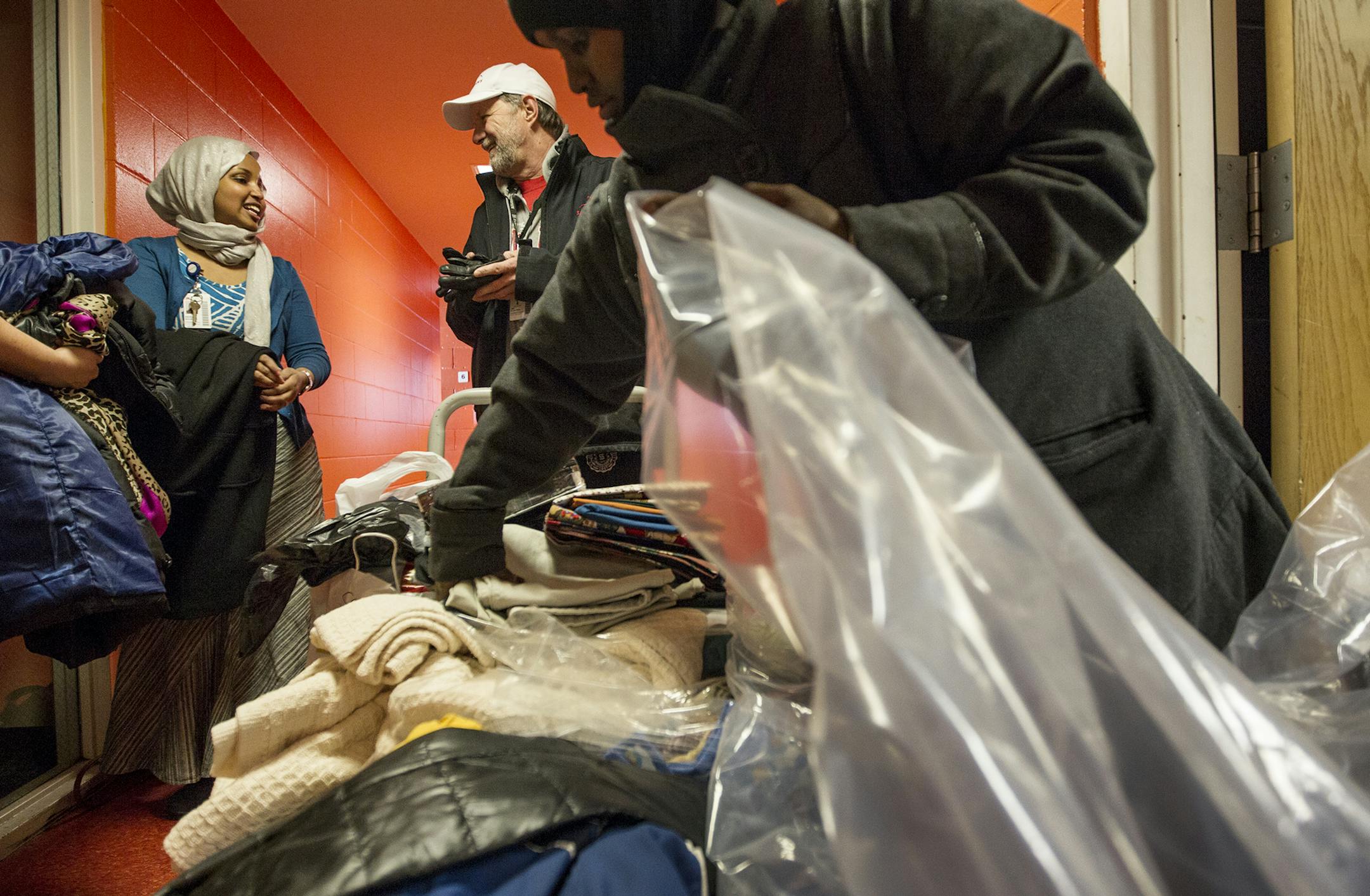 Sahra Noor, Director of Community Health for University of Minnesota Medical Center, Fairview, left, and Jim Platten, Director of Employed Physicians, center, stand by piles of donated items for fire victims from Fairview staff members at the Brian Coyle Center in Minneapolis January 4, 2014. (Courtney Perry/Special to the Star Tribune) ] Moved by the tragedy of the Cedar-Riverside fire on New Years Day, Noor and Platten organized a staff-wide donation drive and delivered multiple truckloads of