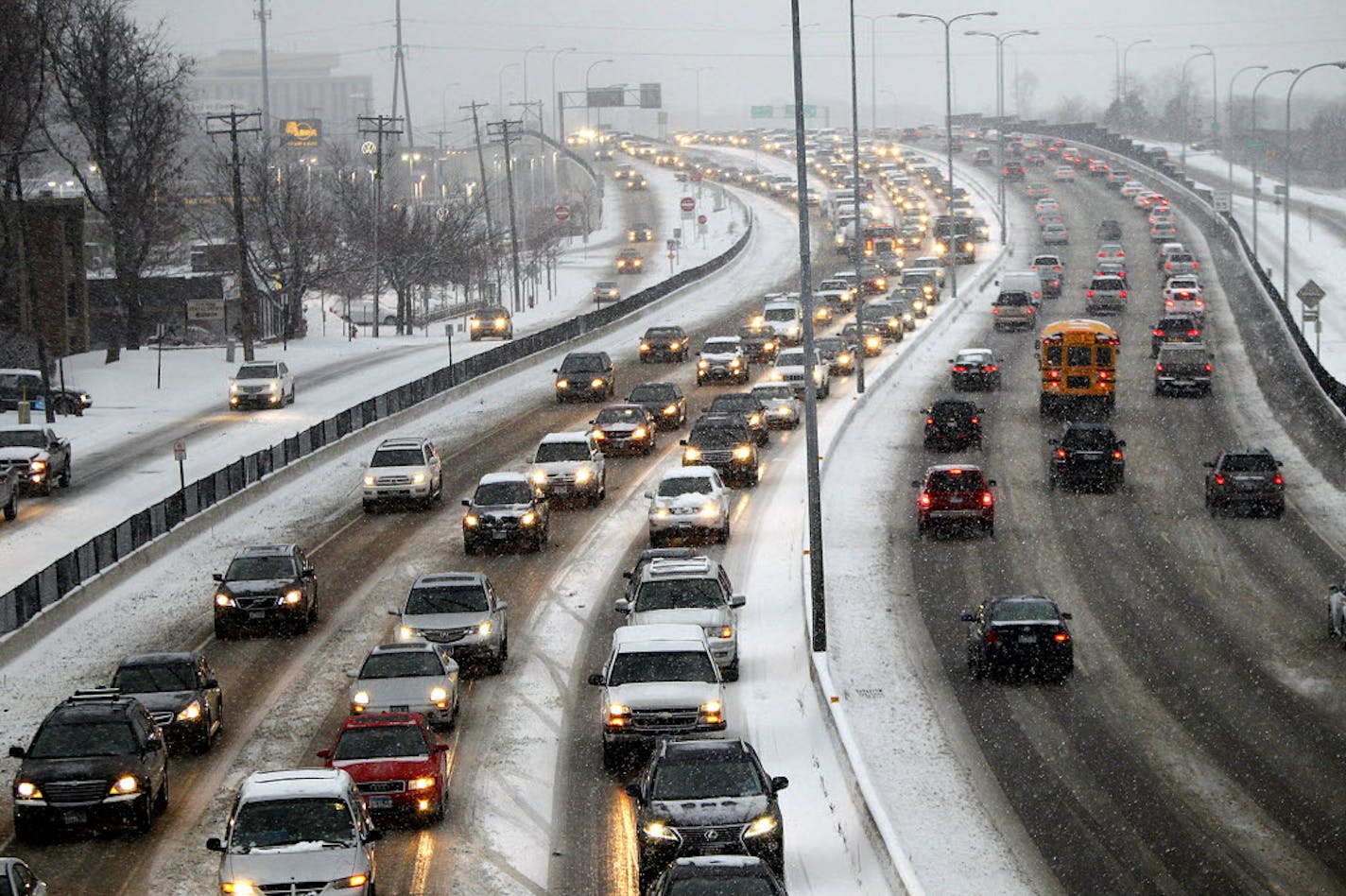 Commuters make their way on Highway 100 as snow falls in St. Louis Park, Minn., Dec. 4, 2013.