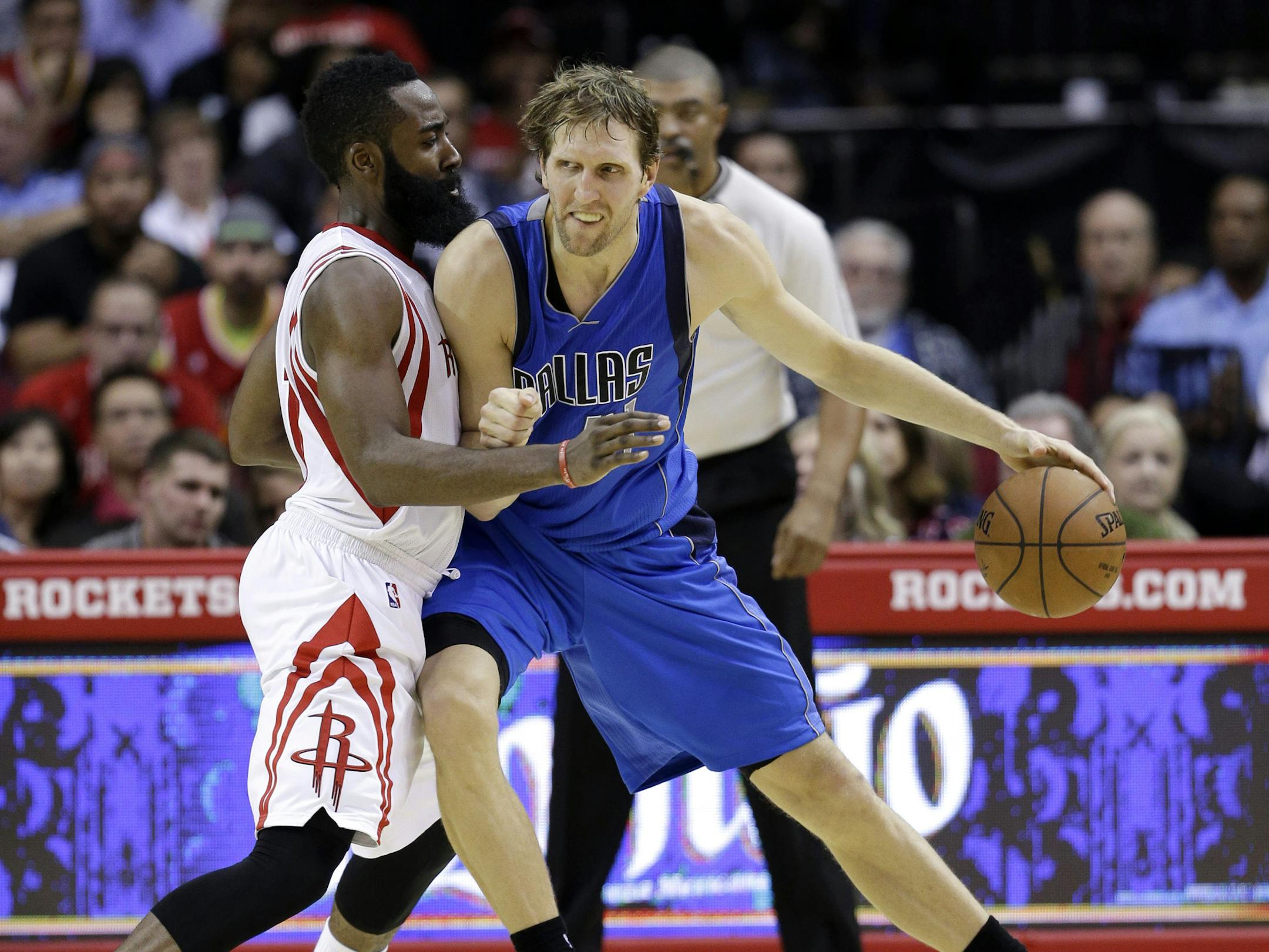 Dallas Mavericks' Dirk Nowitzki, right, works for position against Houston Rockets' James Harden, left, during the fourth quarter of an NBA basketball game Saturday, Nov. 22, 2014, in Houston. The Rockets won 95-92. (AP Photo/David J. Phillip)