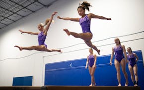 Anna Lentz, left, and Kana Try worked out on the balance beam during practice.