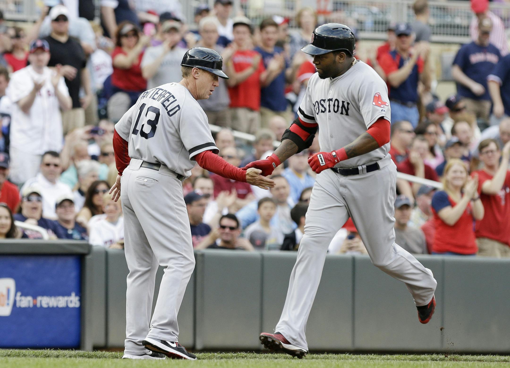 Boston Red Sox' David Ortiz, right, is congratulated by third base coach Brian Butterfield as he rounds third on his three-run home run off Minnesota Twins pitcher Scott Diamond in the first inning of a baseball game, Saturday, May 18, 2013, in Minneapolis. (AP Photo/Jim Mone) ORG XMIT: MIN2013051820240446
