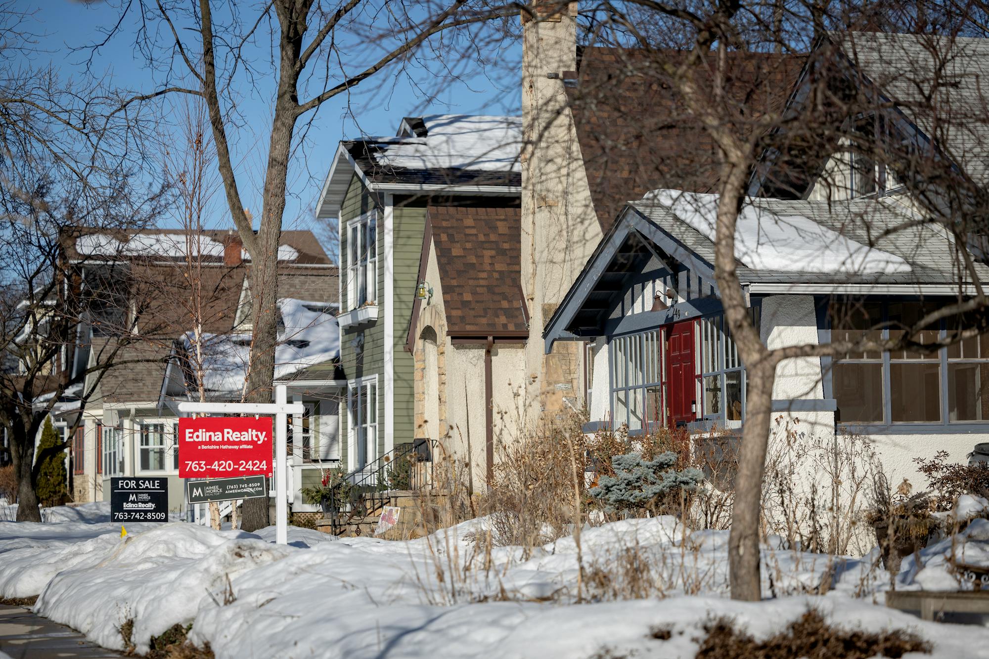 A row of houses in Bryn Mawr. Two houses have for-sale signs in front of them.