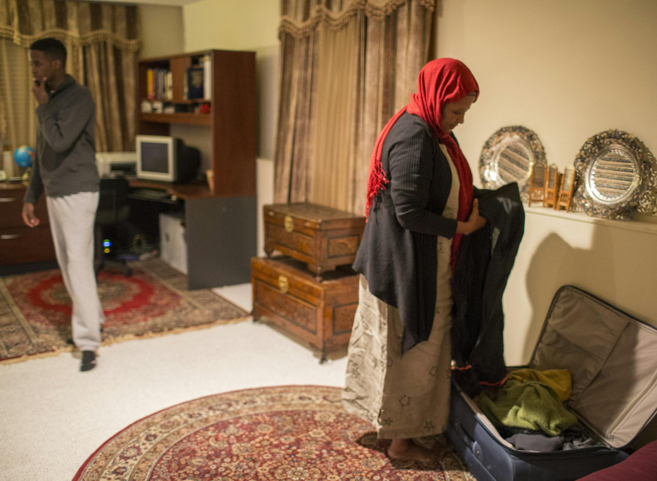 Halima Ibrahim's husband, civil engineer Abdullahi Ali Anshoor, was gunned down in Mogadishu in November. Halima, who is back in Minnesota for a brief visit, is returning to Mogadishu Monday. She was photographed going through her luggage she is packing for the trip on Thursday, January 8, 2015, in Brooklyn Park, Minn. Her son Ayanle Ali is at left. ] RENÉE JONES SCHNEIDER • renee.jones@startribune.com