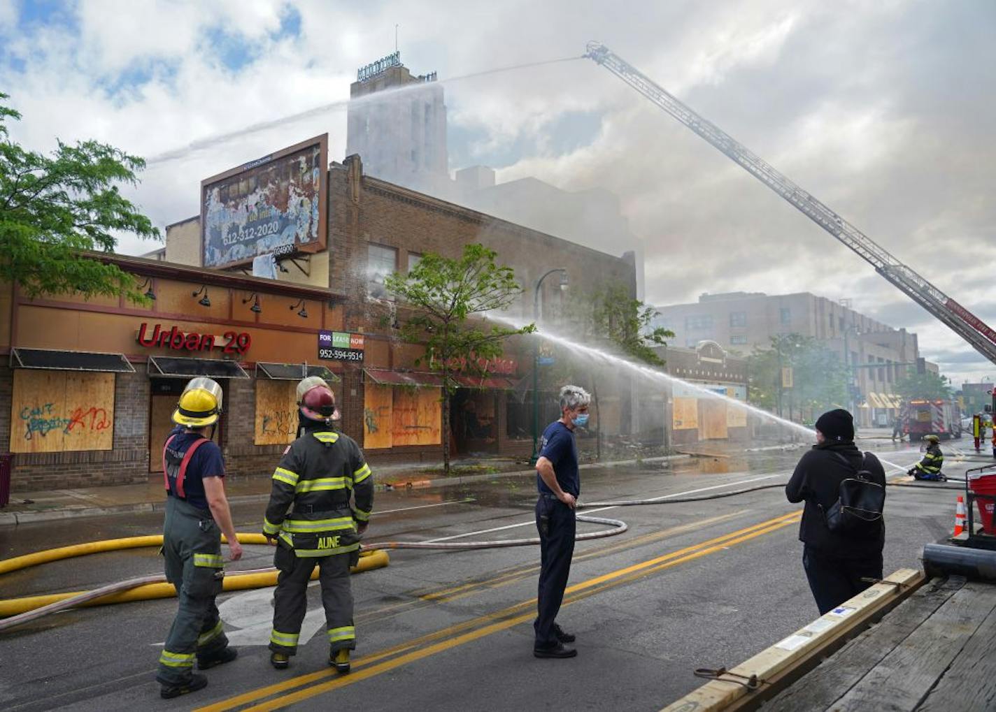 Firefighters talked with Brenda Lenton as she watched her apartment burn above the Foot Locker on Lake Street near Chicago Avenue on May 29.