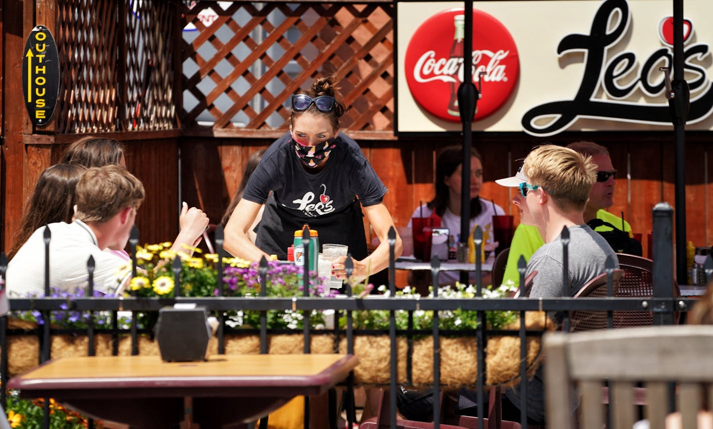 Angie Burger took orders and delivered drinks to customers in the restaurant's outdoor seating. Monday was the first day Minnesota restaurants were allowed to serve customers outdoors.