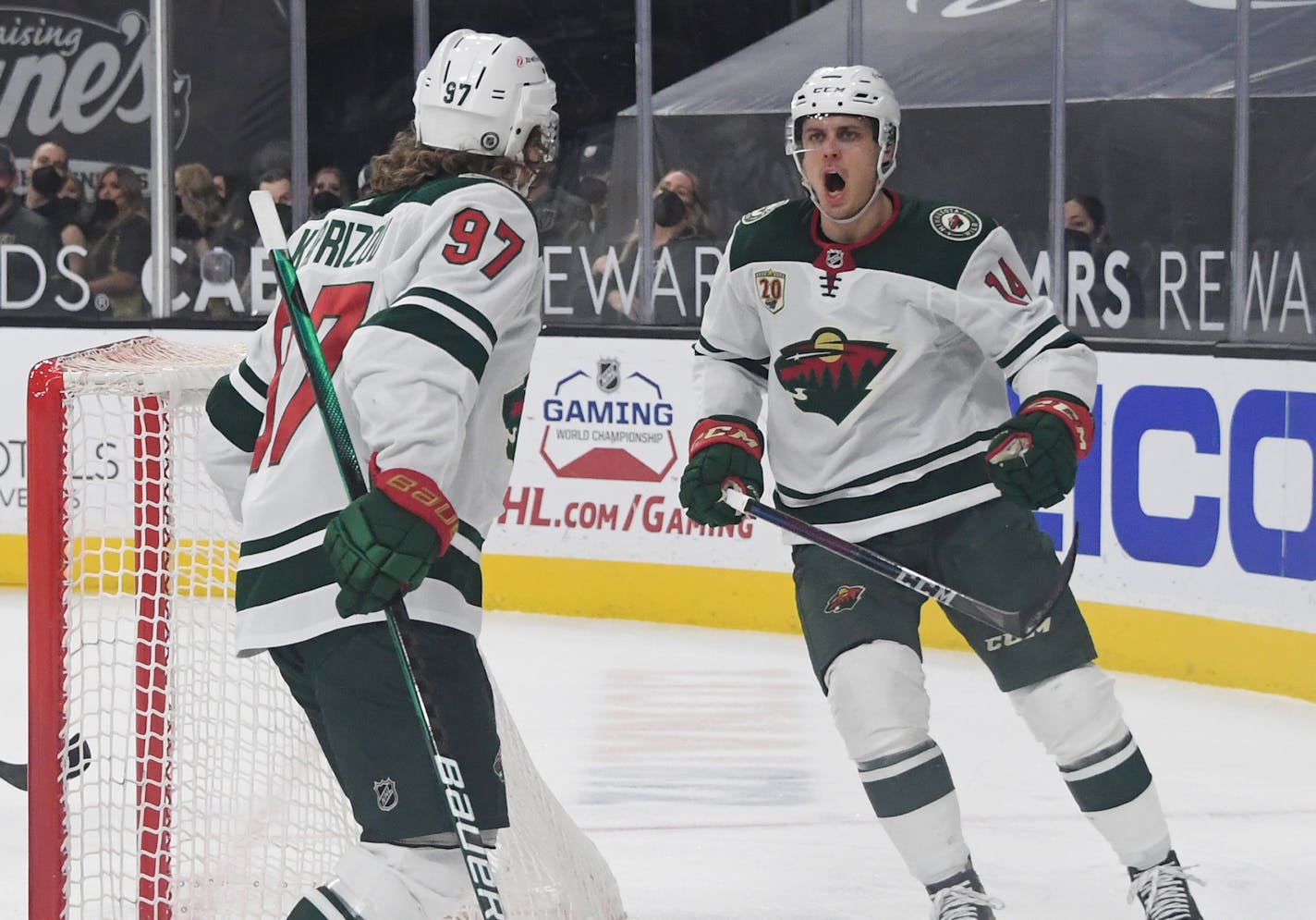 The Wild's Kirill Kaprizov (97) and Joel Eriksson Ek (14) celebrate after Eriksson Ek assisted Kaprizov on a third-period power-play goal against the Vegas Golden Knights