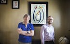 Ian Keith, left, and Brian Singer pose for a portrait in front of a Tingatinga painting that Brian bought in Tanzania.