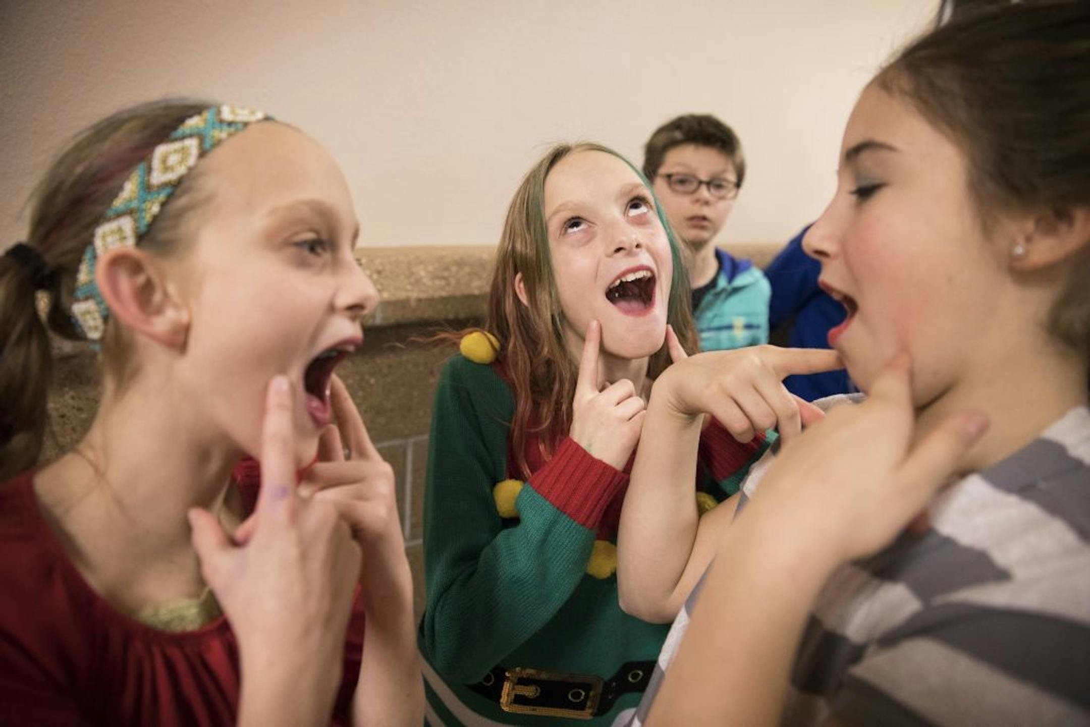 Isabelle, from left, and Abby Carlsen play around with their friend Jadah Alyea during school.